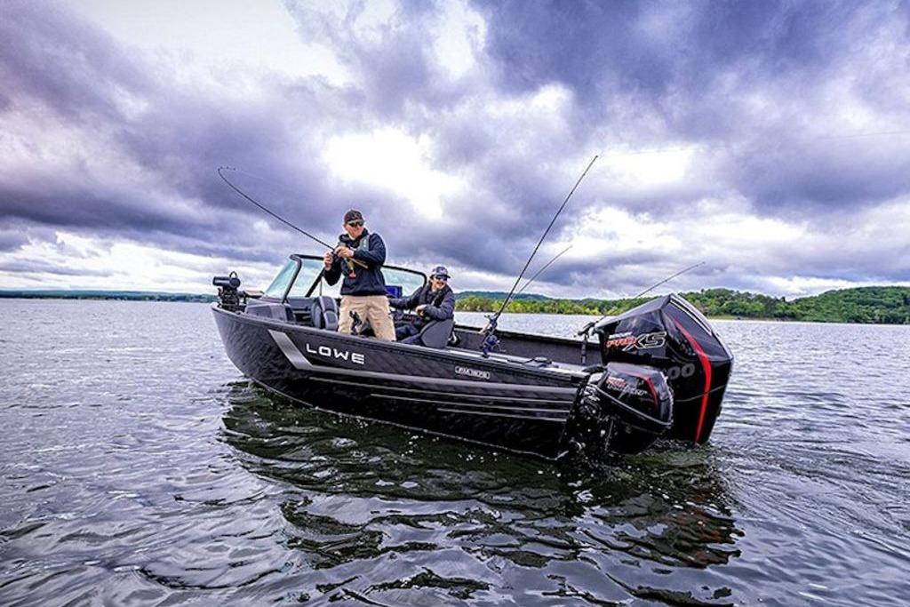2026 Lowe Fishing Machine 1875 on a lake under dramatic cloudy skies.