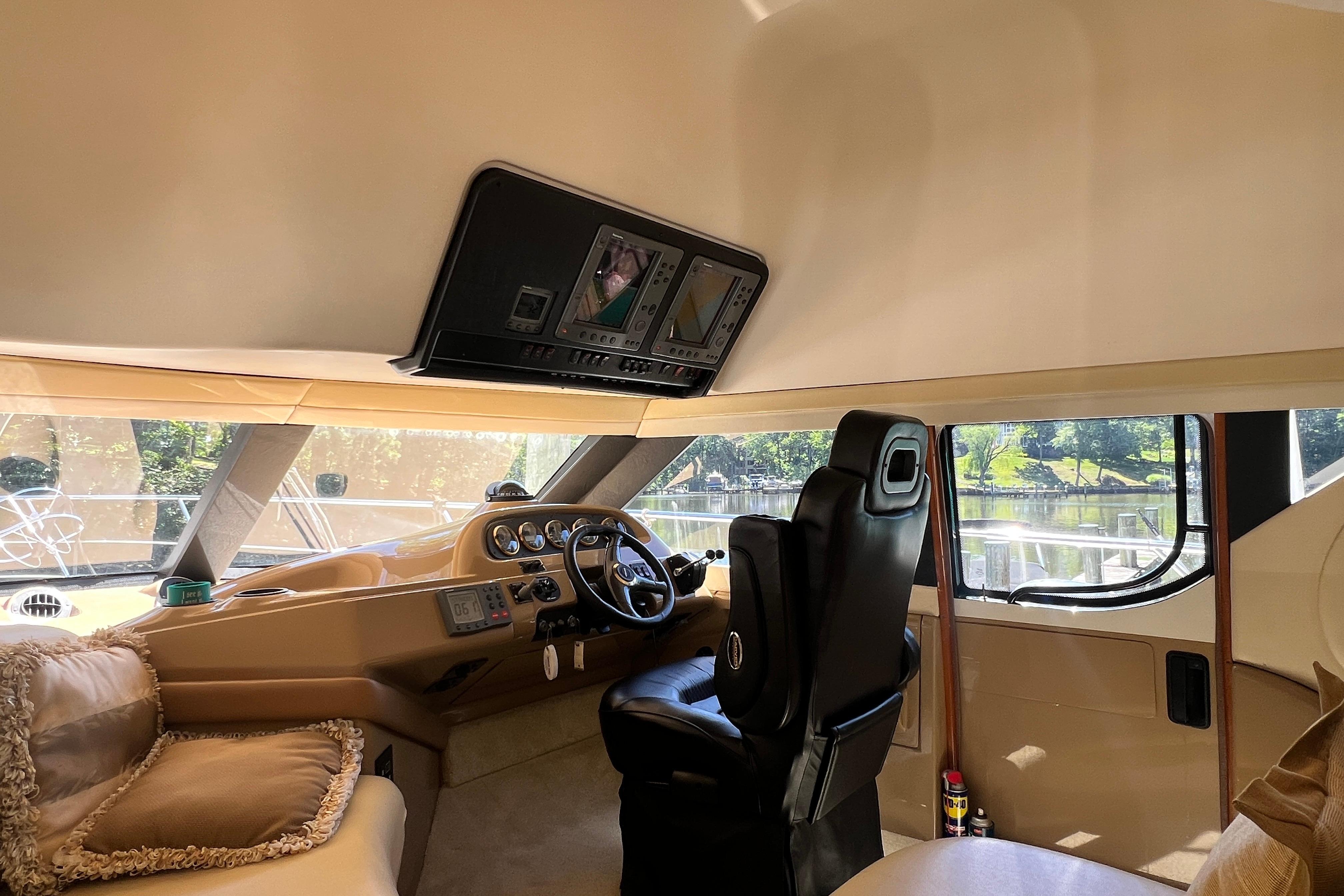 Interior of 2003 Carver 450 Voyager Pilothouse with helm and plush seating.