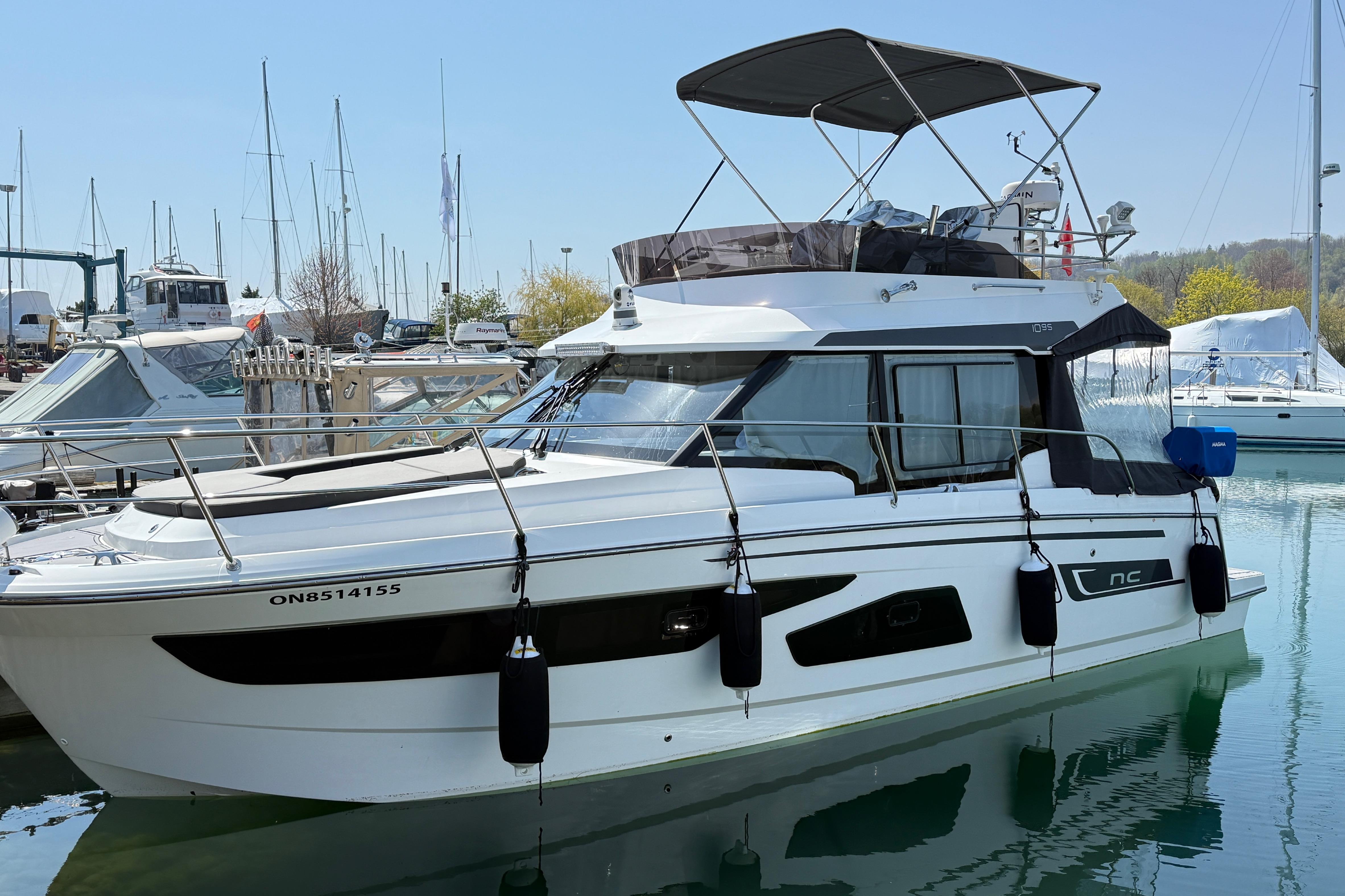 2022 Jeanneau NC 1095 Fly yacht docked in a marina, featuring sleek design and modern amenities.