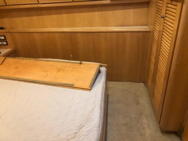 1997 Bertram Convertible cabin interior with bed and wooden panel.