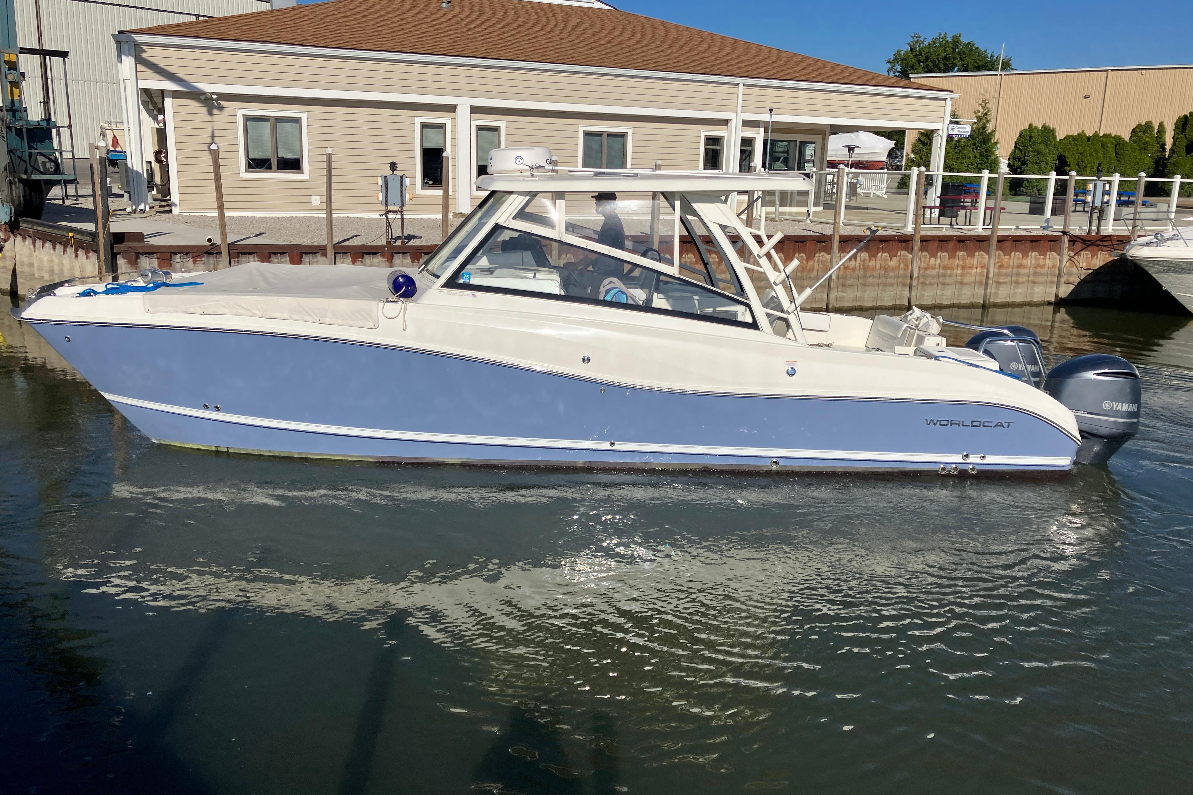 2021 World Cat 320 DC boat docked in marina, featuring sleek design and dual engines.