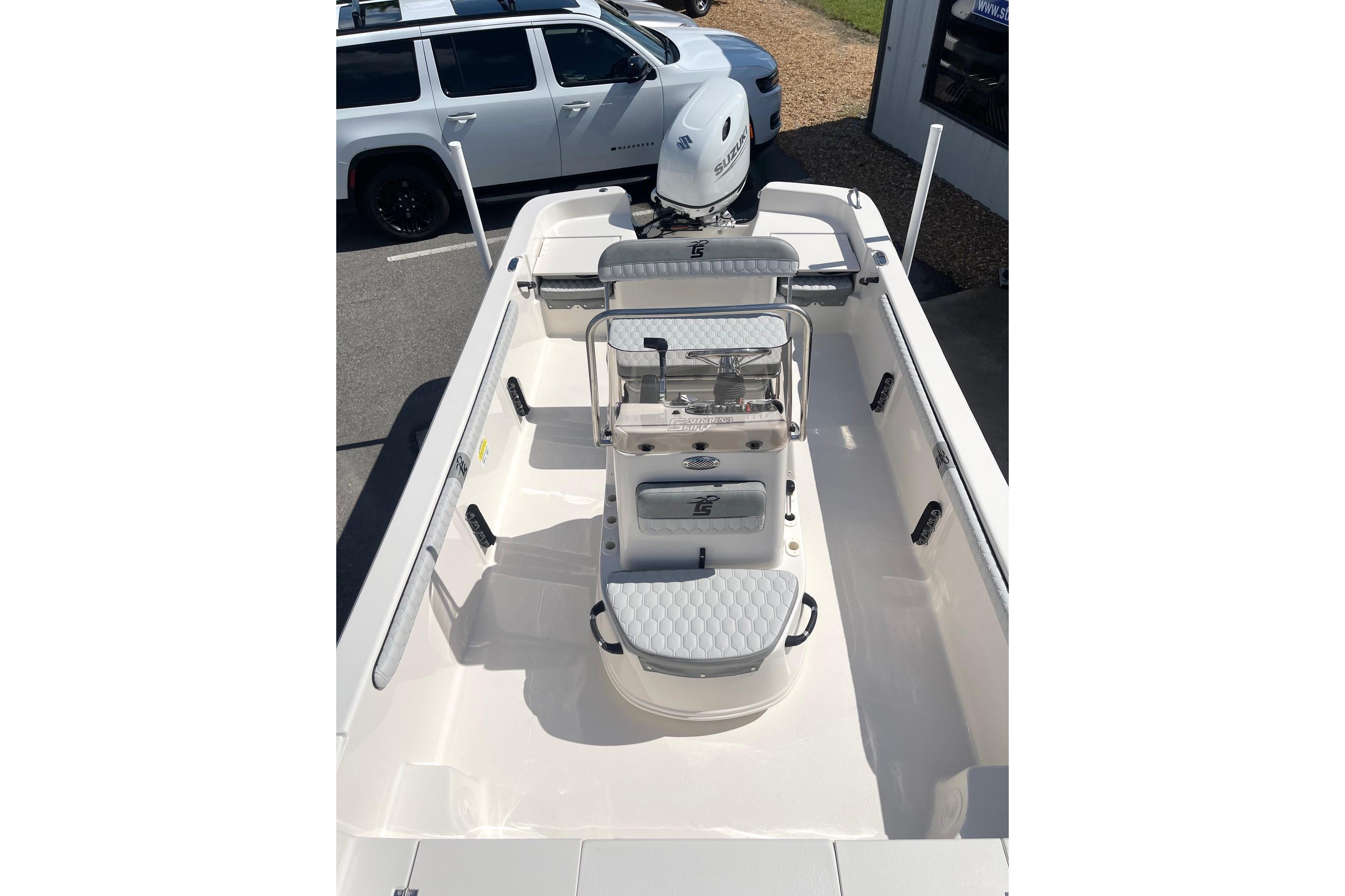 2026 Carolina Skiff 19 LS boat interior with seating and console, parked outdoors.