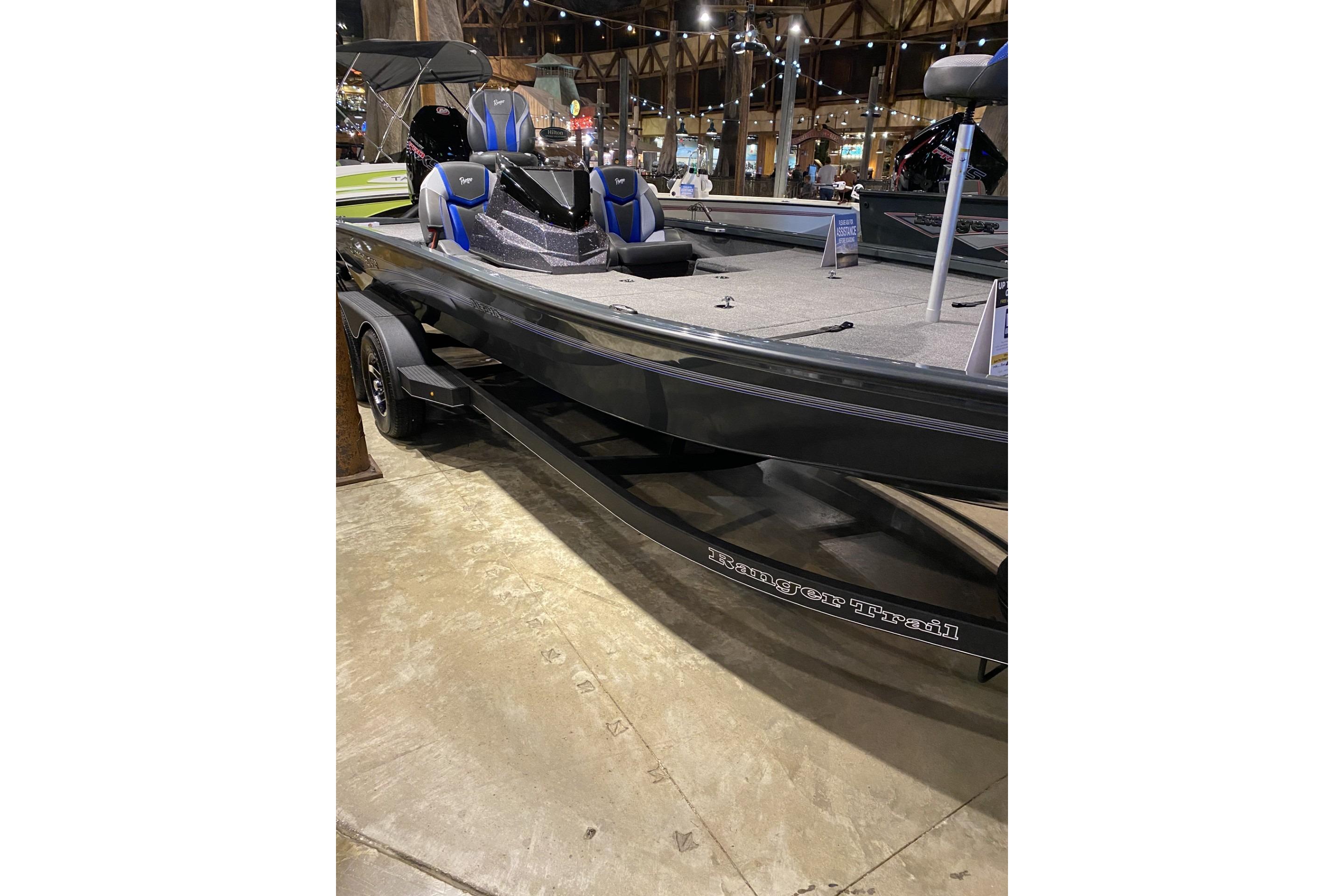 2025 Ranger ALPHA 208 boat displayed indoors, featuring sleek design and blue-accented seats.