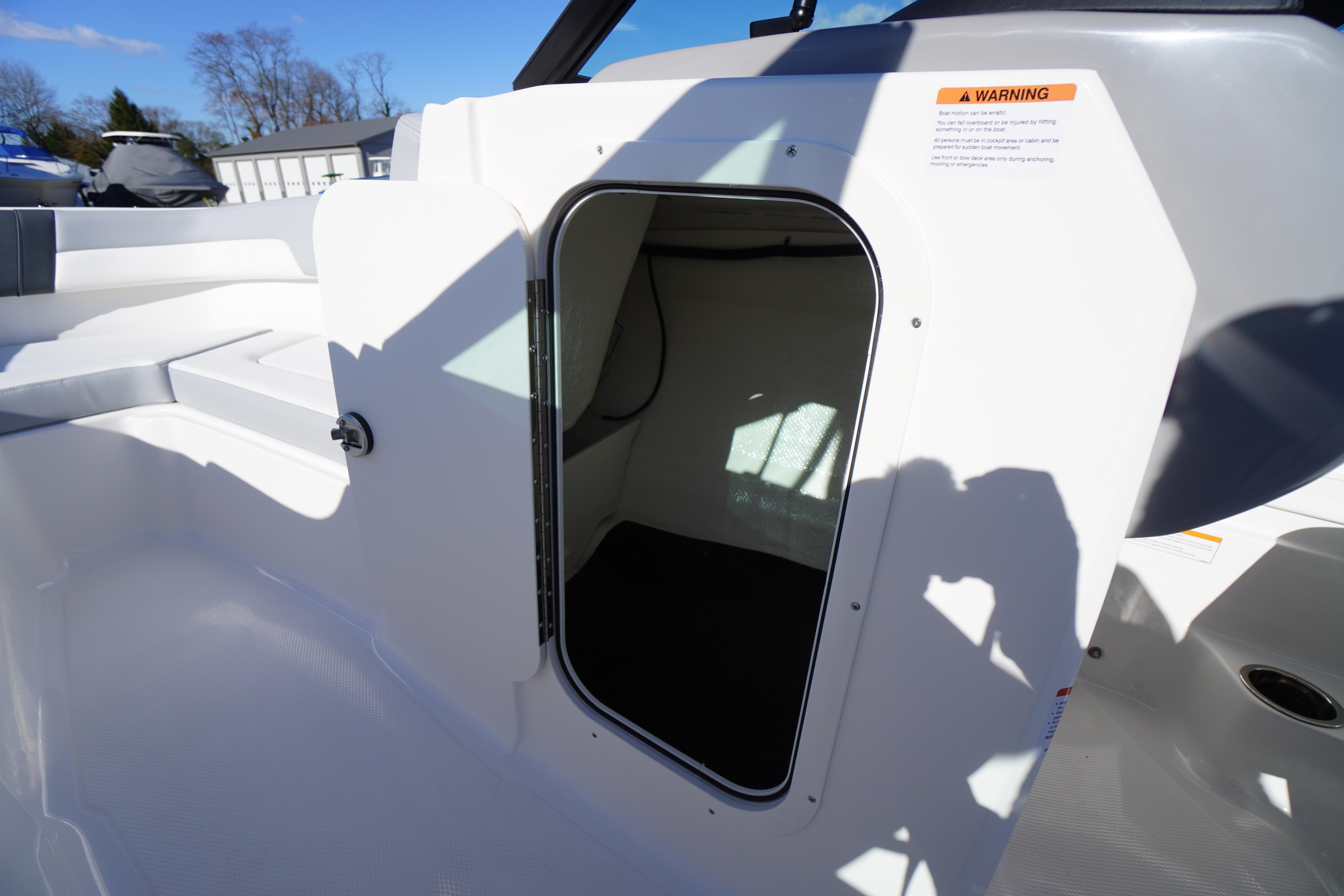2026 Chaparral 23 SSi boat interior storage compartment with open hatch.