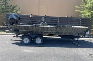 2026 Tracker Grizzly 2072 CC boat on trailer, parked outdoors.