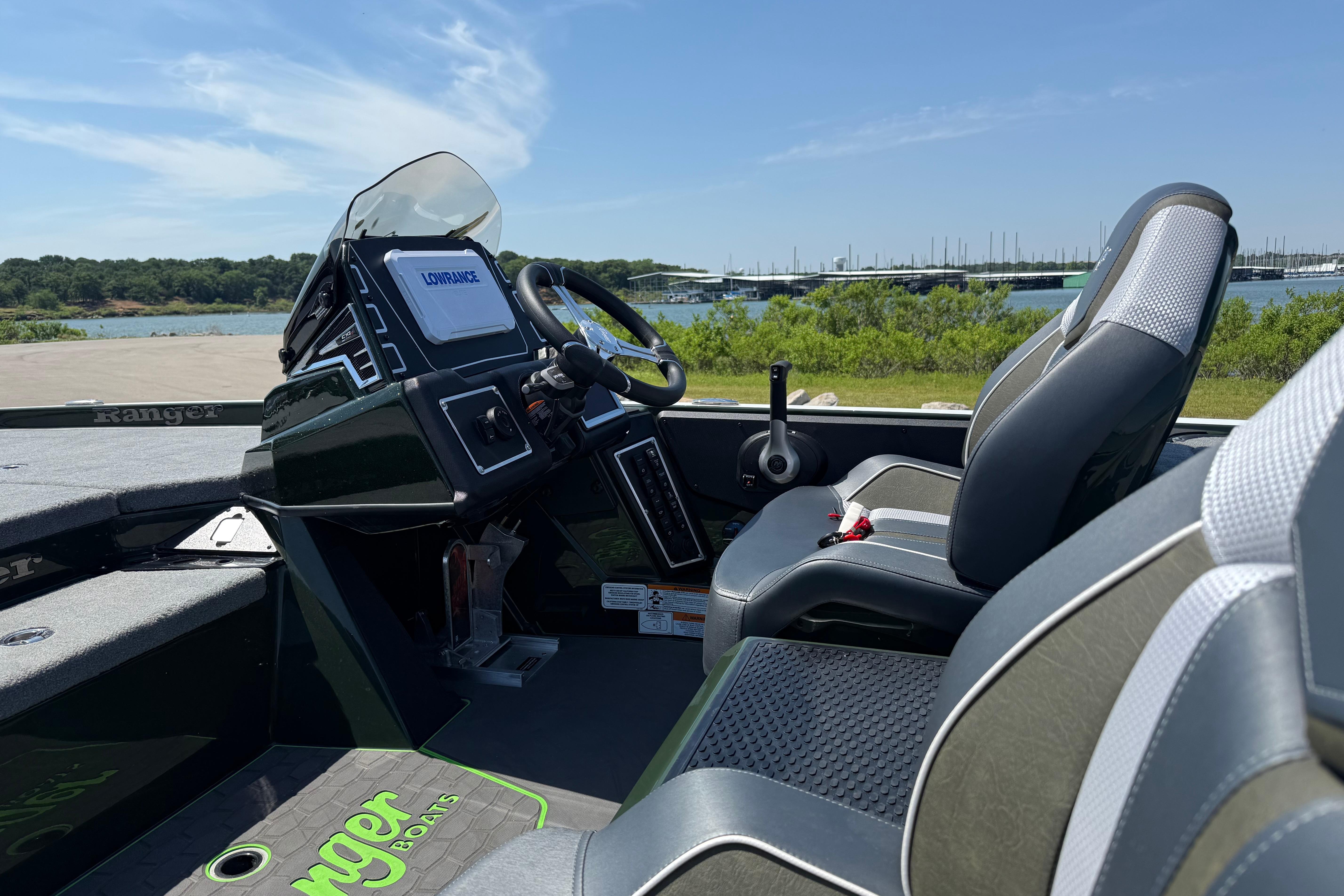 2026 Ranger Z519R boat interior with steering wheel, seats, and control panel by a scenic lake.