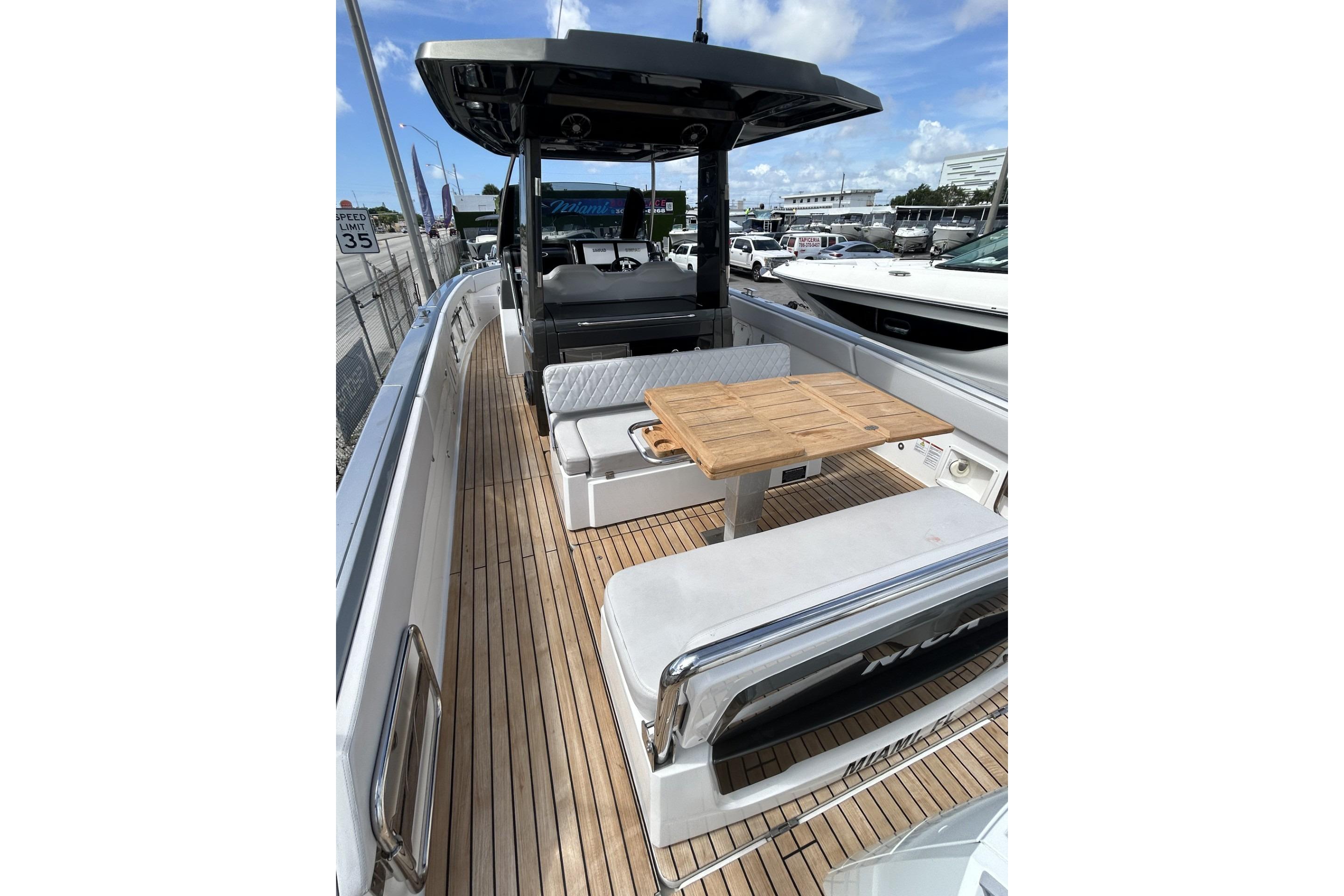 2023 Schaefer V33 yacht with teak deck and seating area, docked under blue sky.