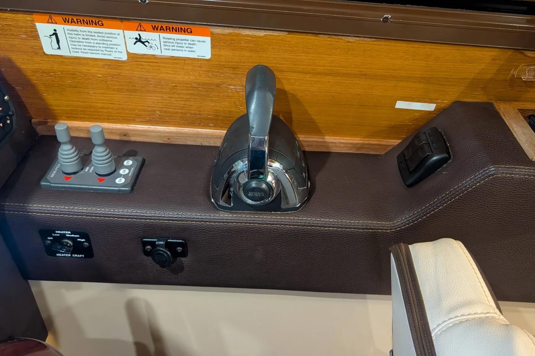 Control panel of a 2015 Ranger Tugs R-29 S boat with throttle and warning labels.