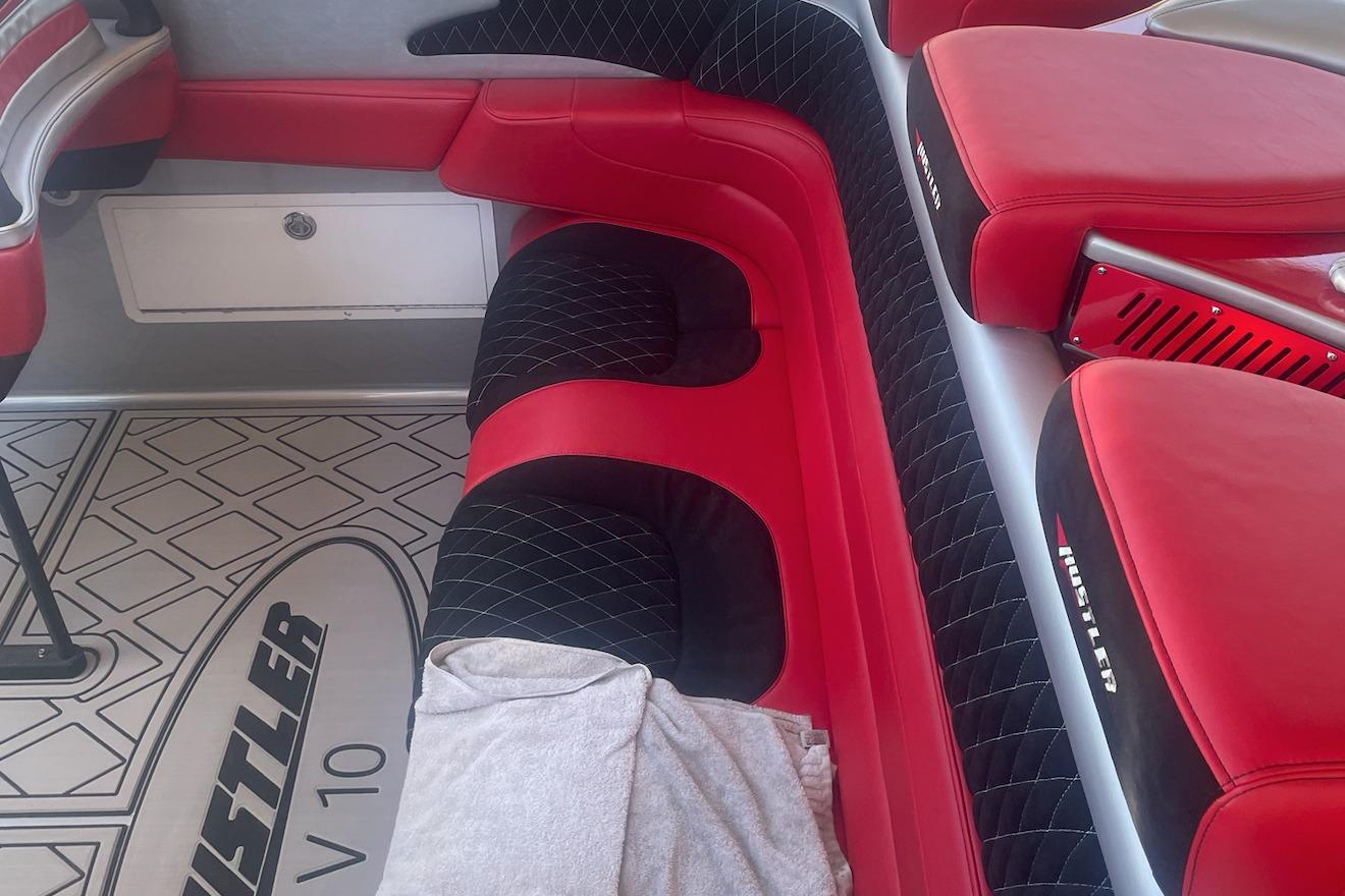 Red and black interior of a 2005 Hustler 388 SLINGSHOT boat.