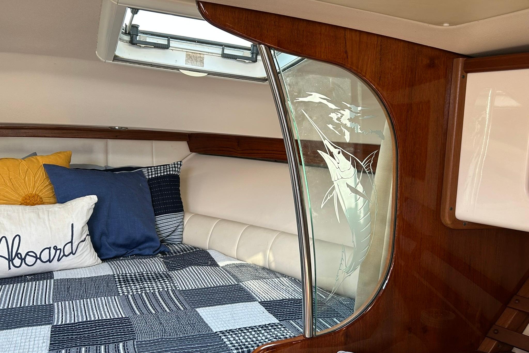 Cozy cabin interior of 2007 Grady-White Express 360 with nautical decor and etched glass.