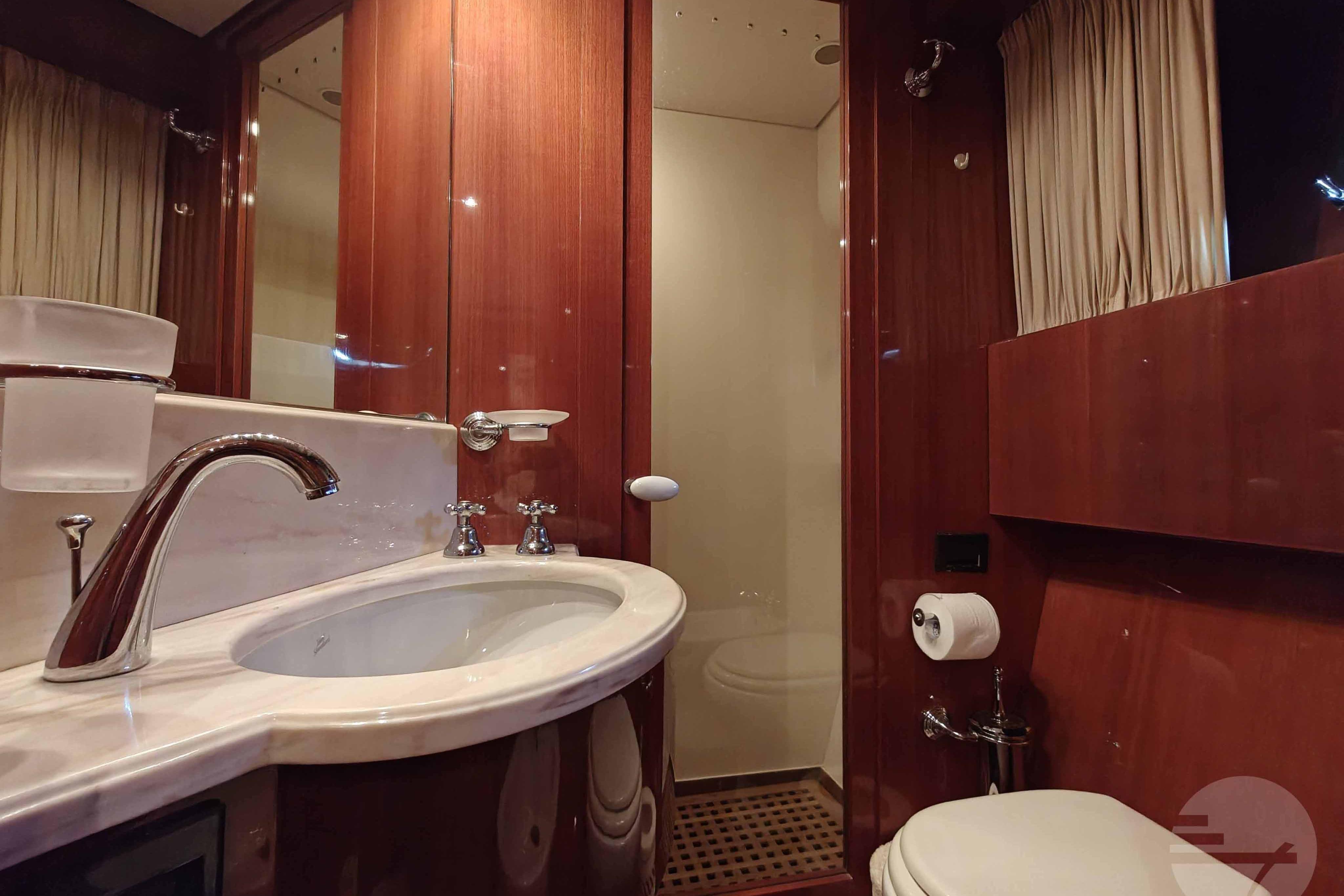Luxurious bathroom in 1999 Sanlorenzo SL82 yacht with wood paneling and modern fixtures.