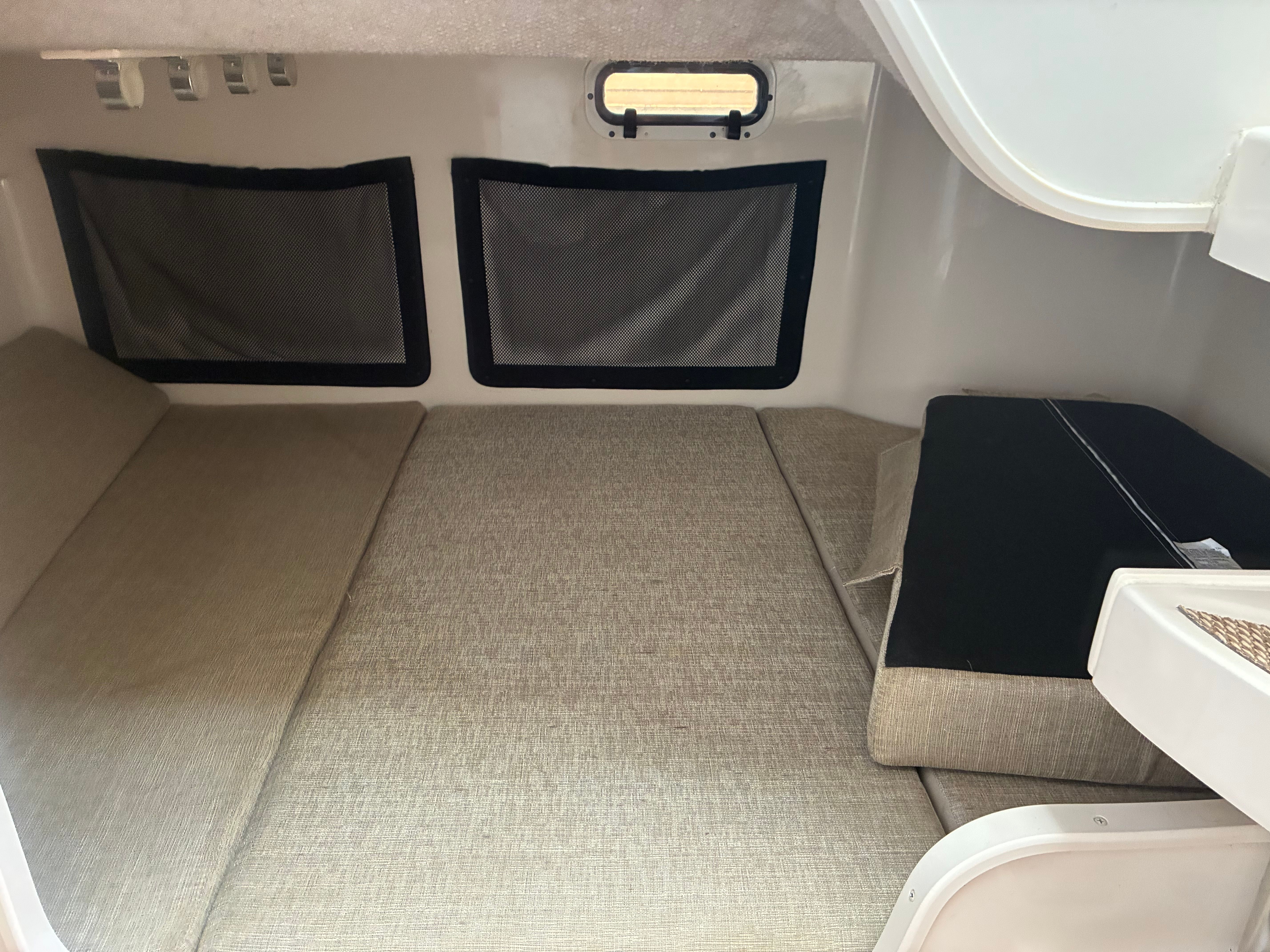 Interior of the 2017 Grady-White Marlin 300 with cushioned seating and windows.