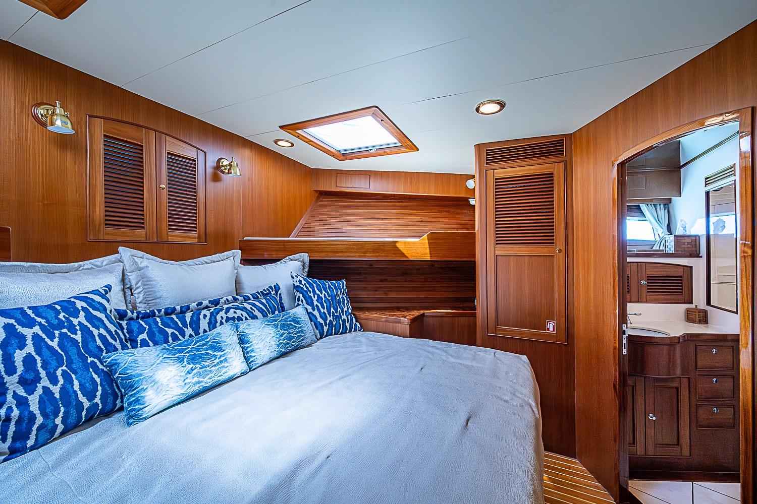 Luxurious cabin interior of 2014 Marlow 80 Explorer yacht with wood paneling and skylight.