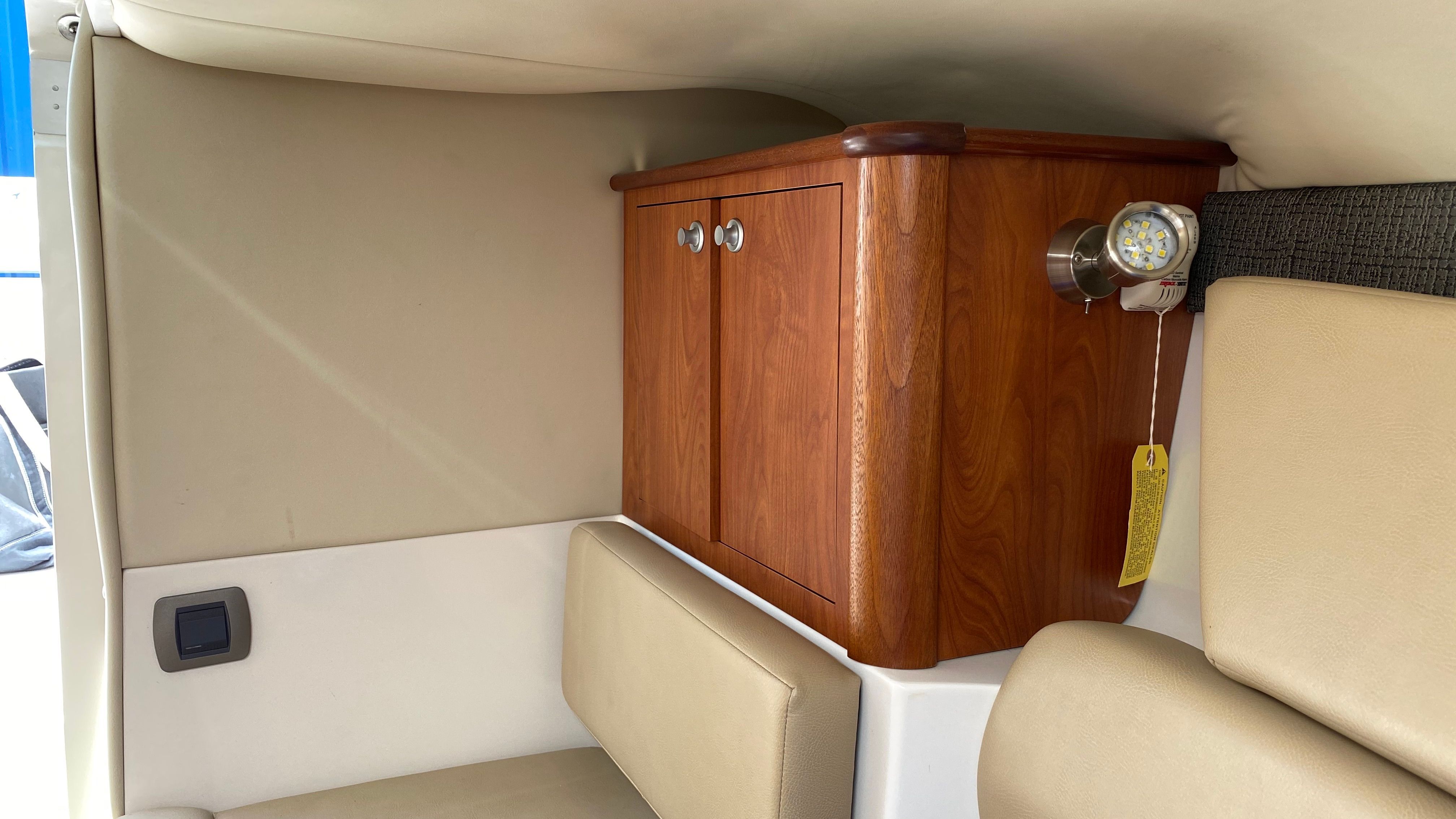 Interior of a boat with a wooden cabinet and beige upholstery.