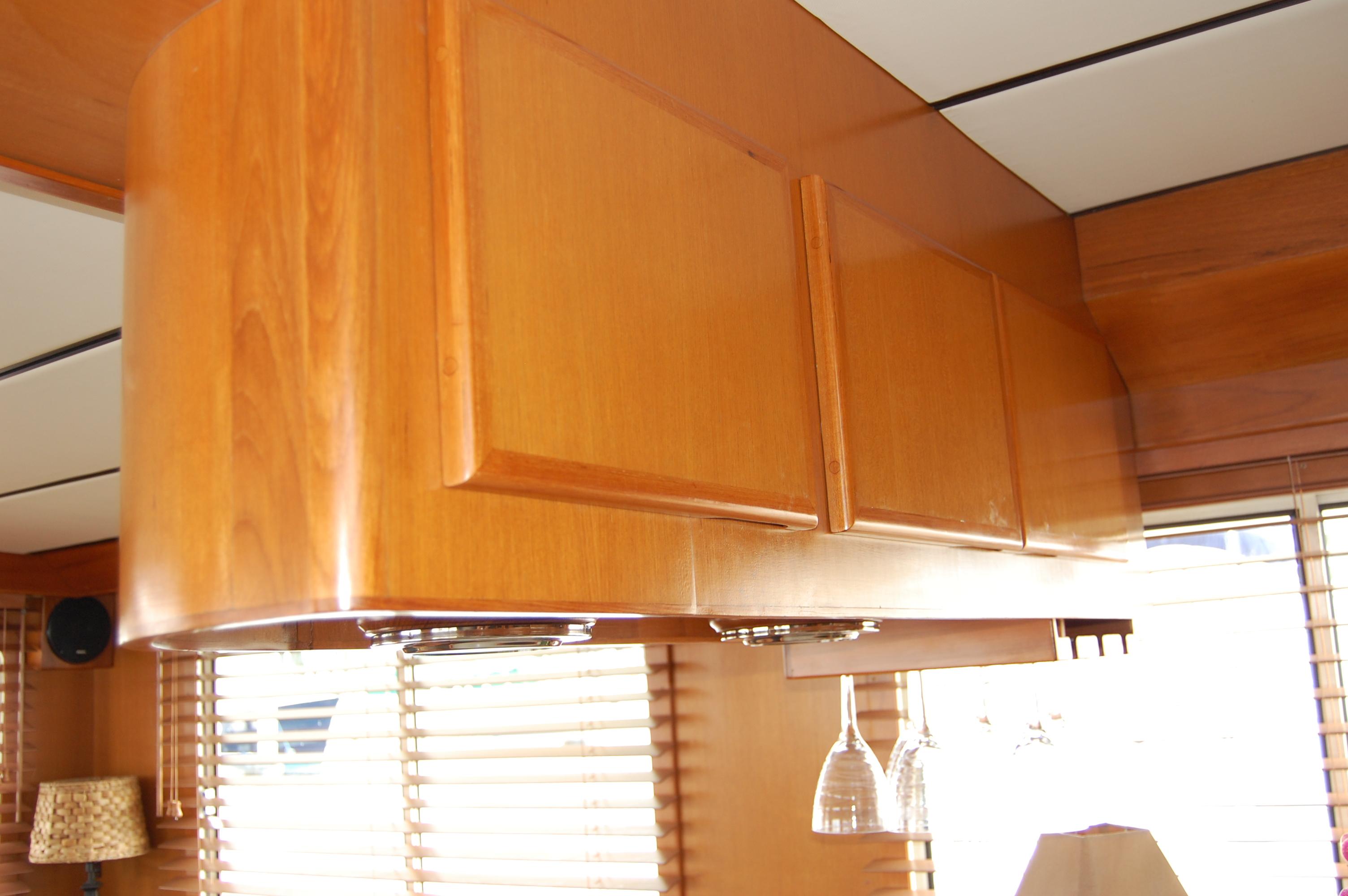 Wooden cabinets in a 2002 Eagle Pilothouse interior with hanging wine glasses.