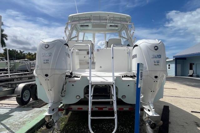 2023 World Cat 325 DC boat with dual Yamaha 300 V6 engines, docked outdoors.