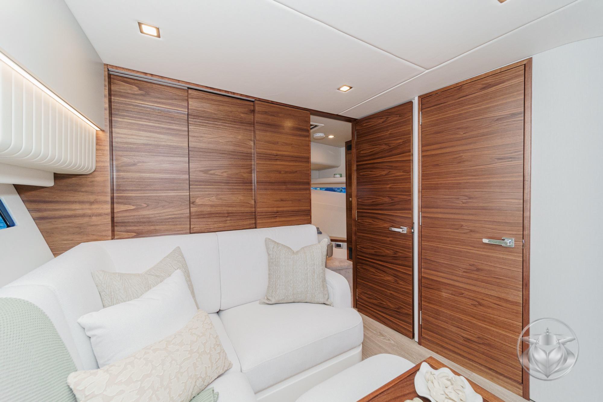 Luxurious interior of 2026 Riviera 4300 Sport Express yacht with elegant wood paneling.