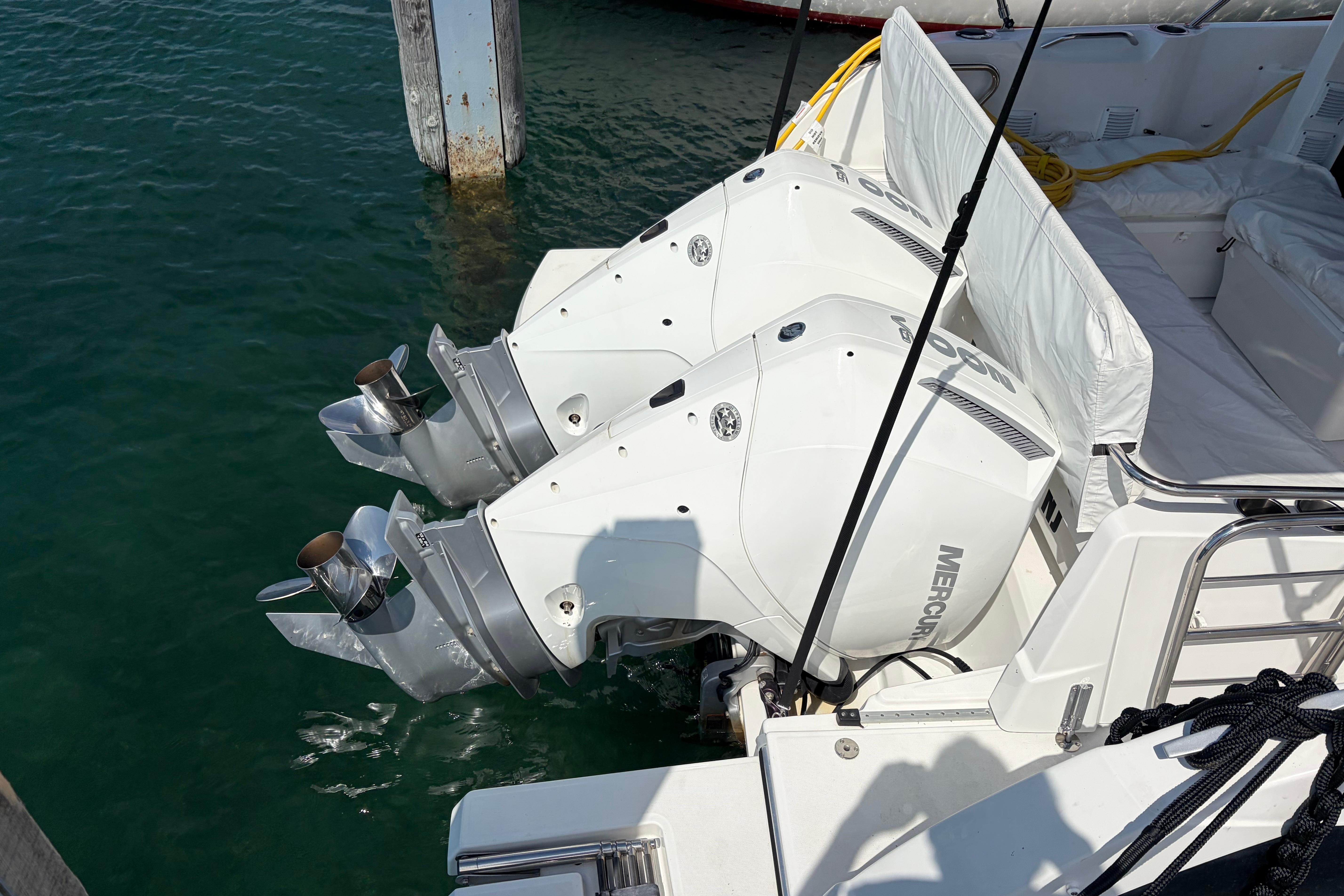 Twin Mercury outboard engines on a 2024 Beneteau Antares 9, docked in clear water.