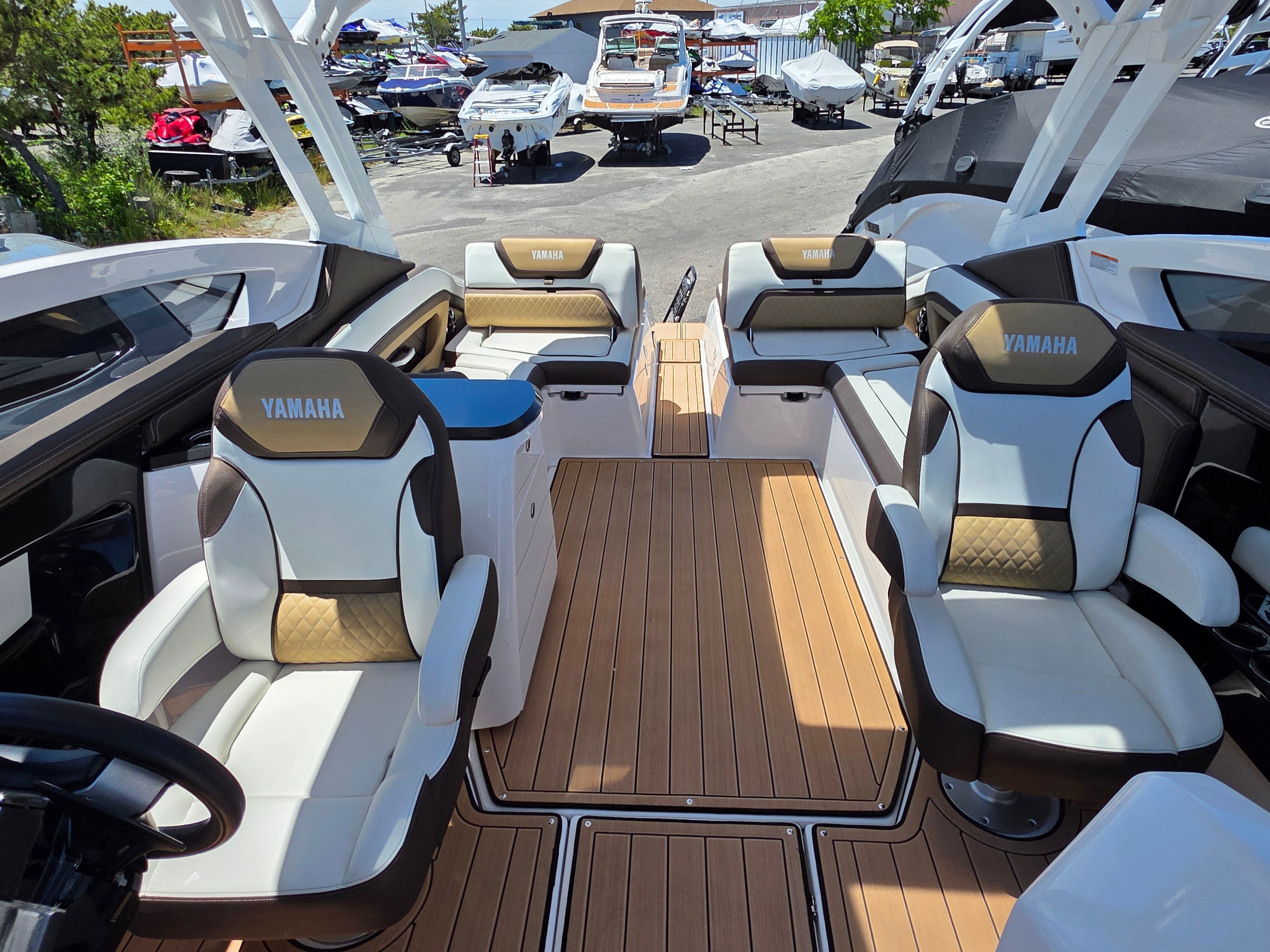 The image shows the interior of a 2023 Yamaha sd275 boat with luxurious seating and wood flooring.