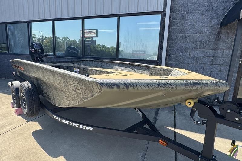 2026 Tracker Grizzly 1756 T Marsh boat on trailer, parked outside a building.