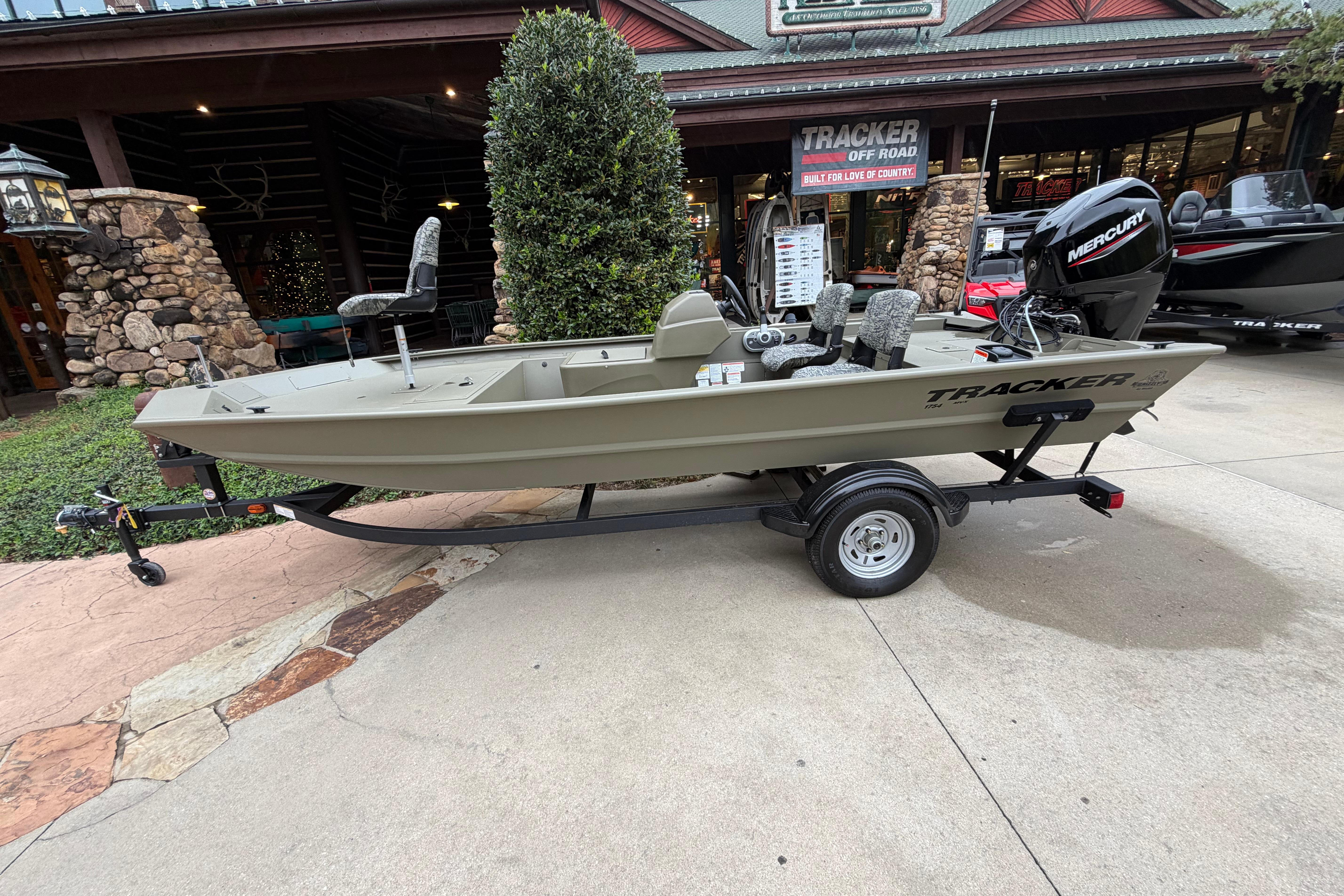 2026 Tracker Grizzly 1754 SC boat on trailer, displayed outside a store.