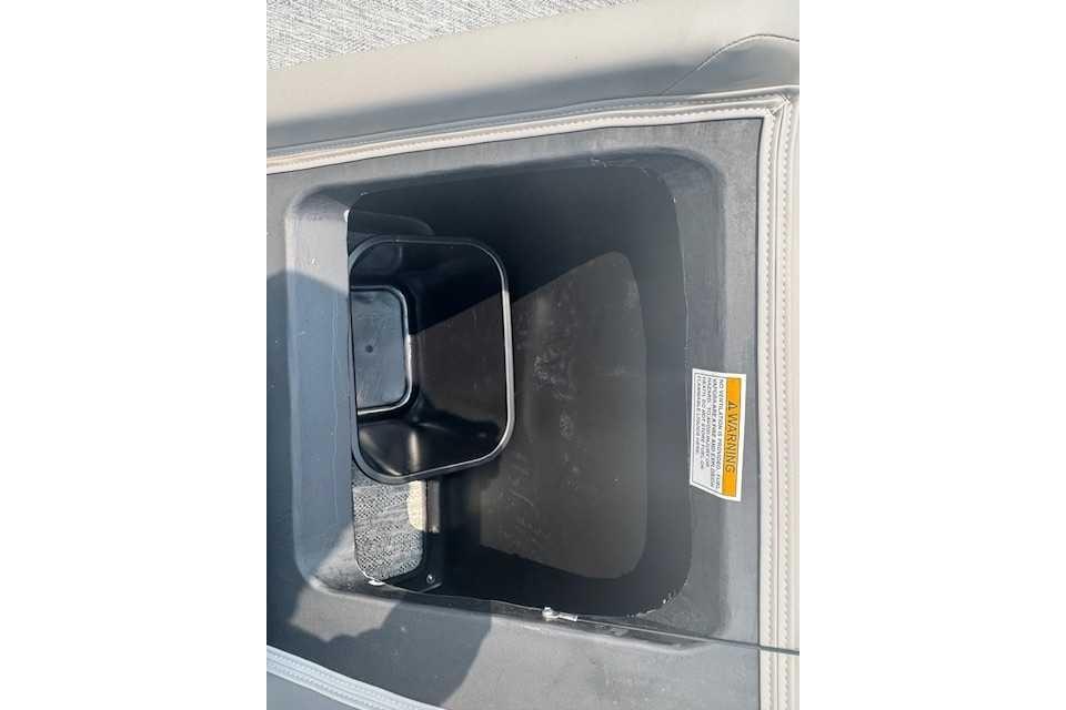 Storage compartment in 2025 Premier 220 SUNSCAPE RL boat, featuring a black container.