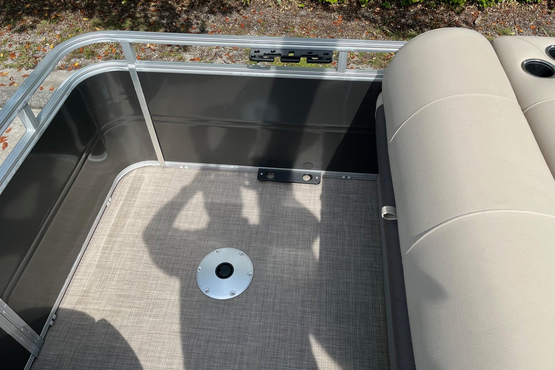 2025 Sun Tracker Fishin' Barge 20 DLX interior with beige seating and metal railing.