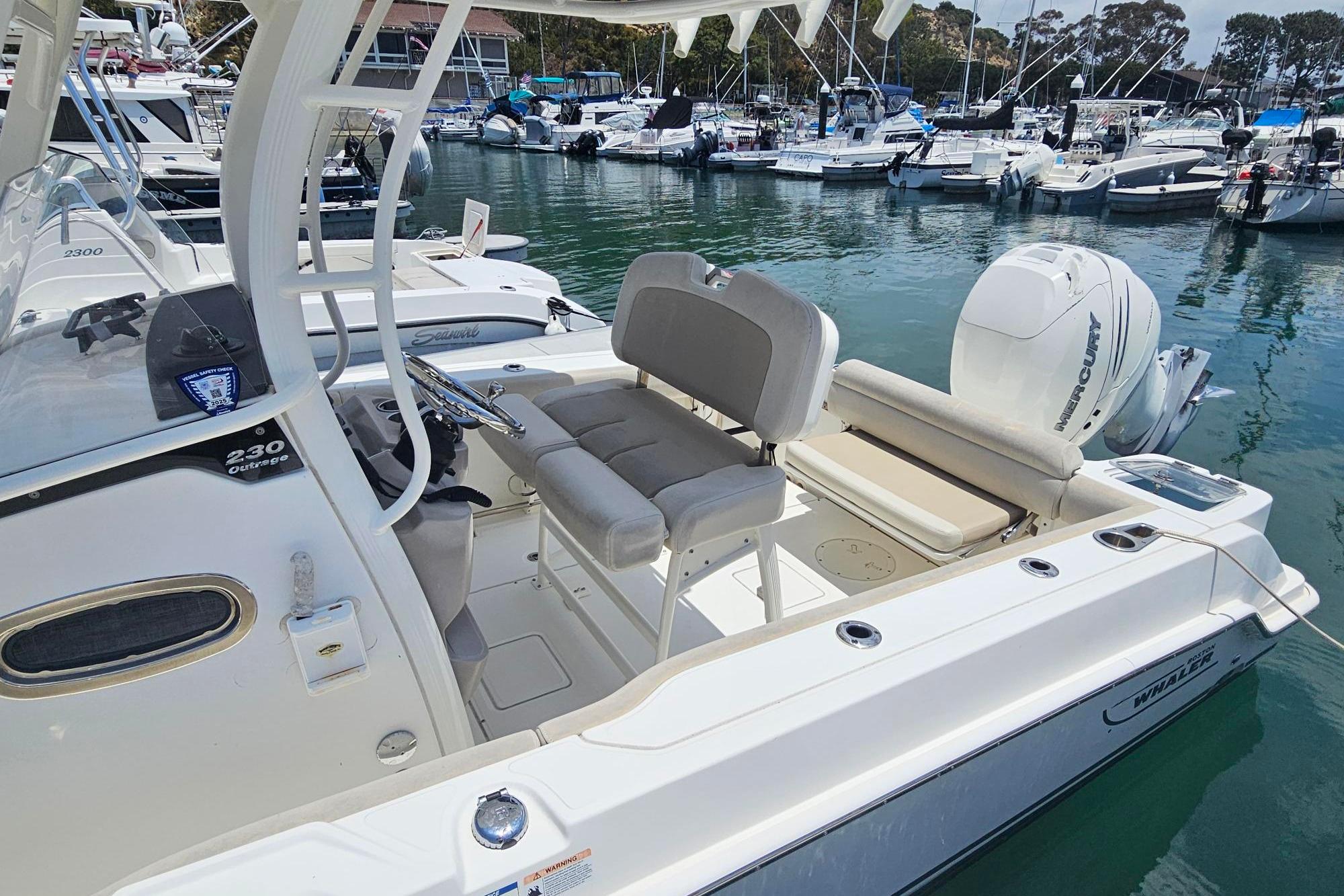 2017 Boston Whaler 230 Outrage boat docked in marina, featuring sleek design and powerful engine.