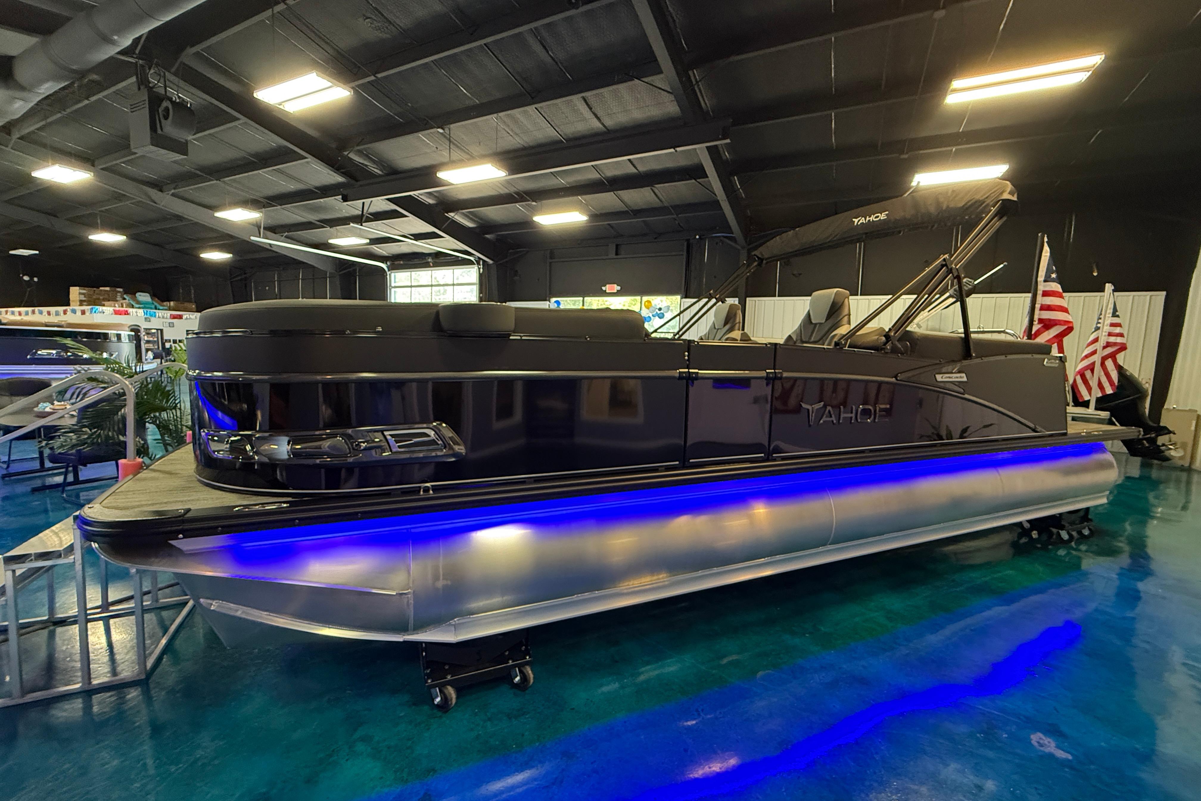 2026 Tahoe Pontoon Cascade Cruise Rear Bench with blue LED lights in showroom.