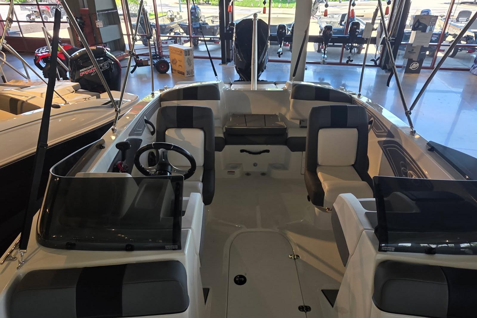 2026 Tahoe T21 boat interior with seating and steering wheel in showroom.