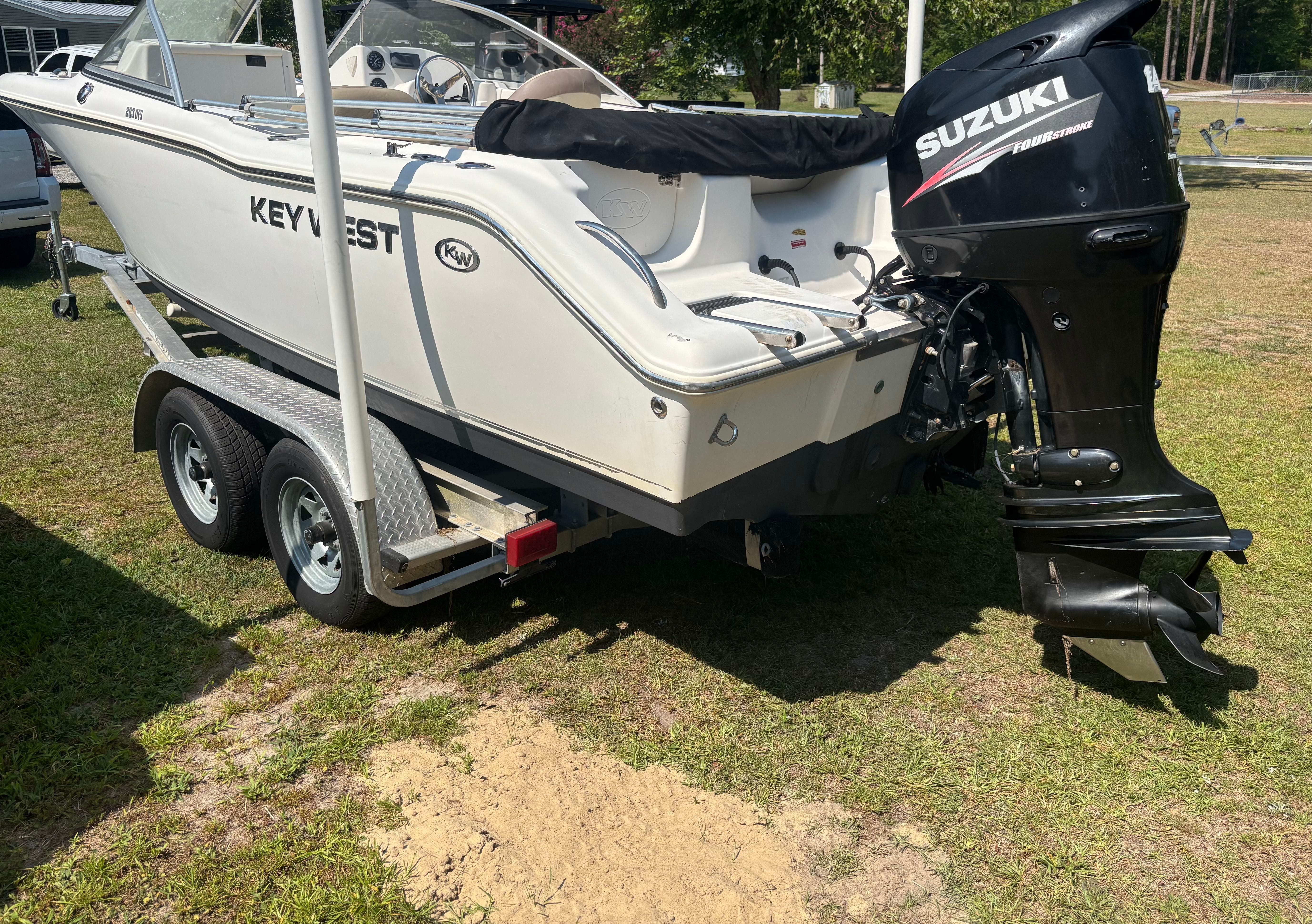 A 2016 Key West 203 DFS boat on a trailer with a Suzuki outboard motor.