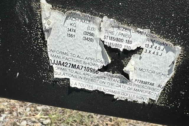 Torn label on a 2021 Bennington L Bowrider 25 Quad Bench, showing weight and tire specifications.