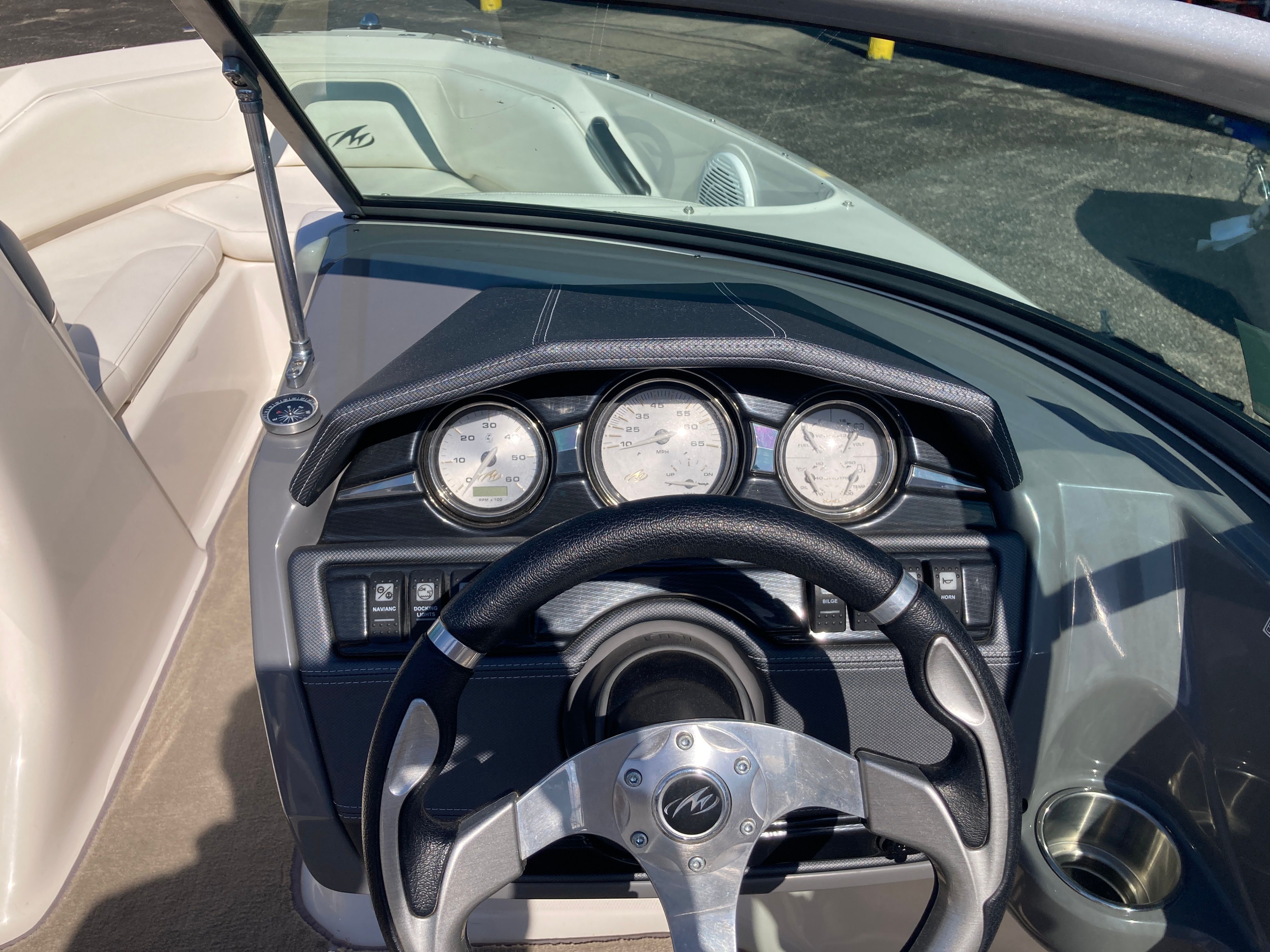 Dashboard of a 2012 Monterey 204FS boat with steering wheel and gauges.