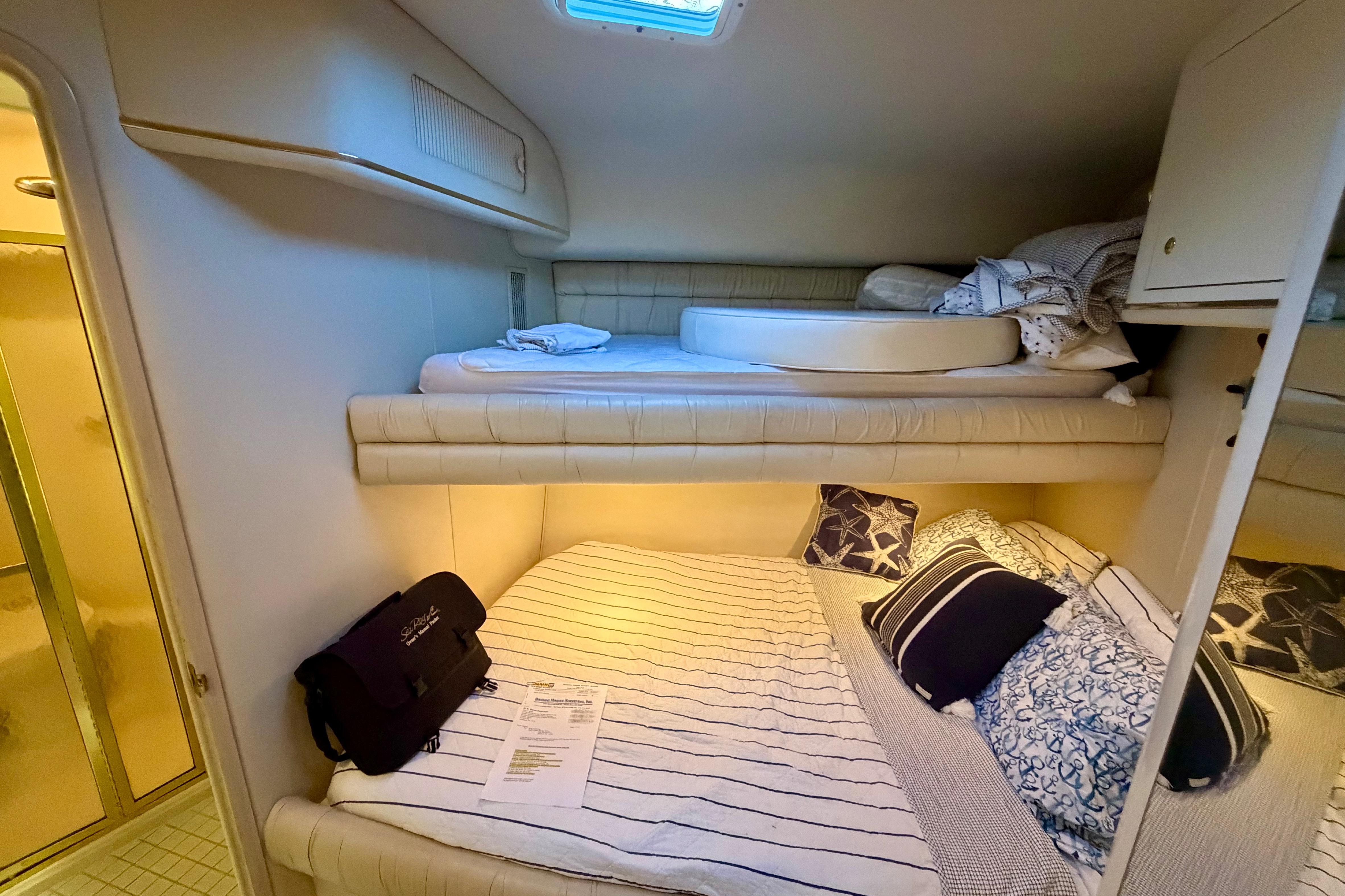 Interior cabin of 1997 Sea Ray 500 Sundancer with cozy bunk beds and nautical decor.