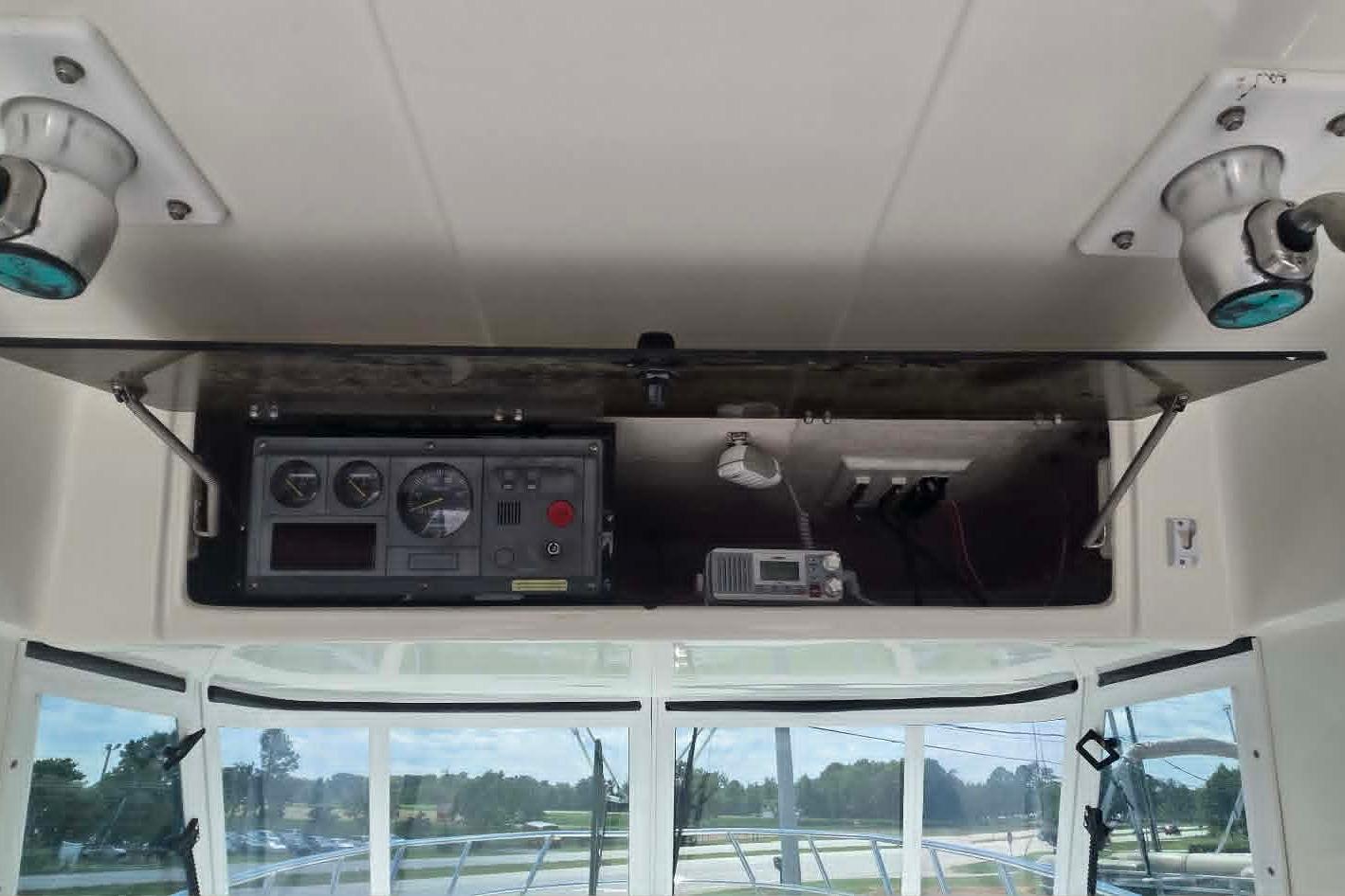 2003 True World Marine 286 boat dashboard with gauges and electronics in open compartment.