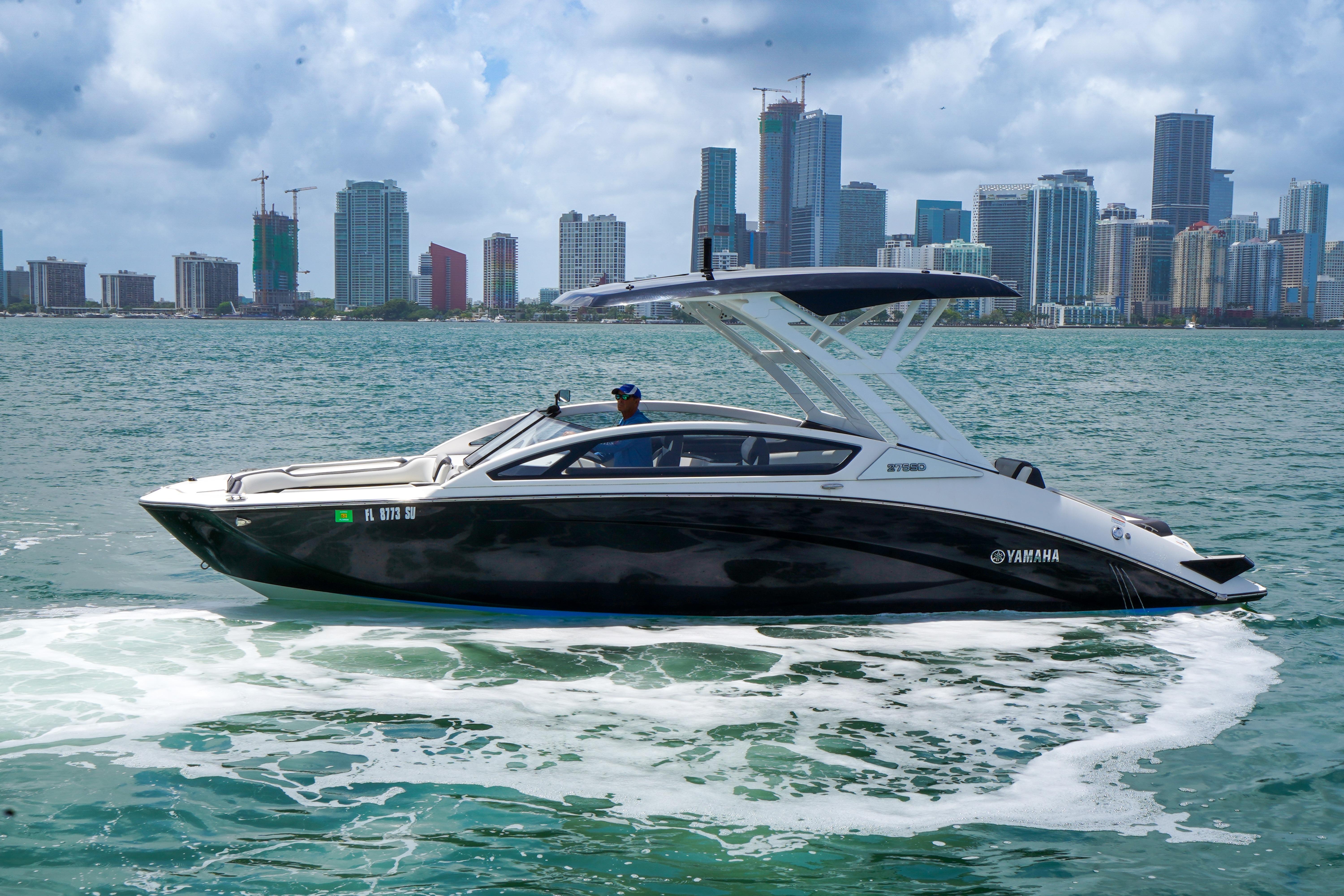 2021 Yamaha Boats 275SD cruising in urban waterfront setting.