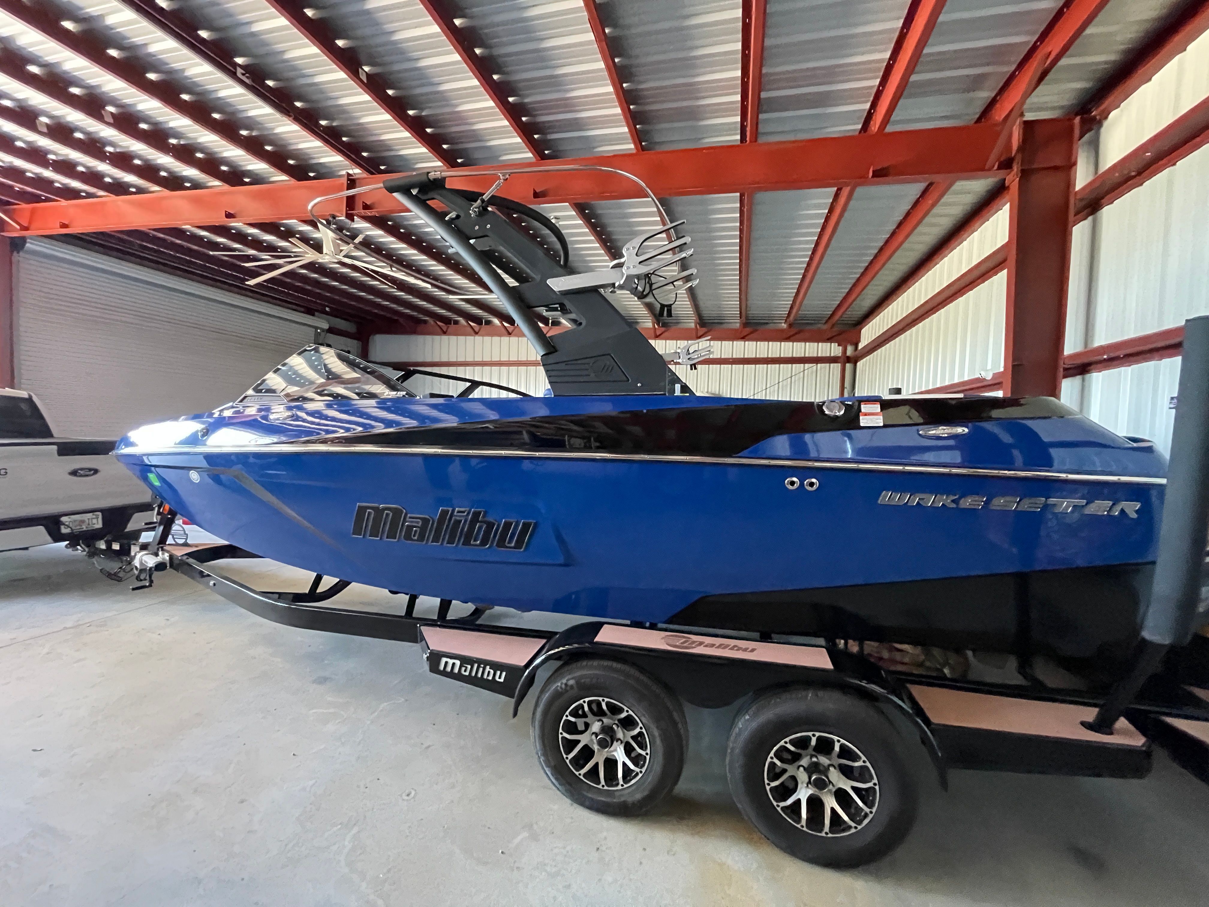 A blue 2019 Malibu Wakesetter 22 LSV on a trailer inside a warehouse.
