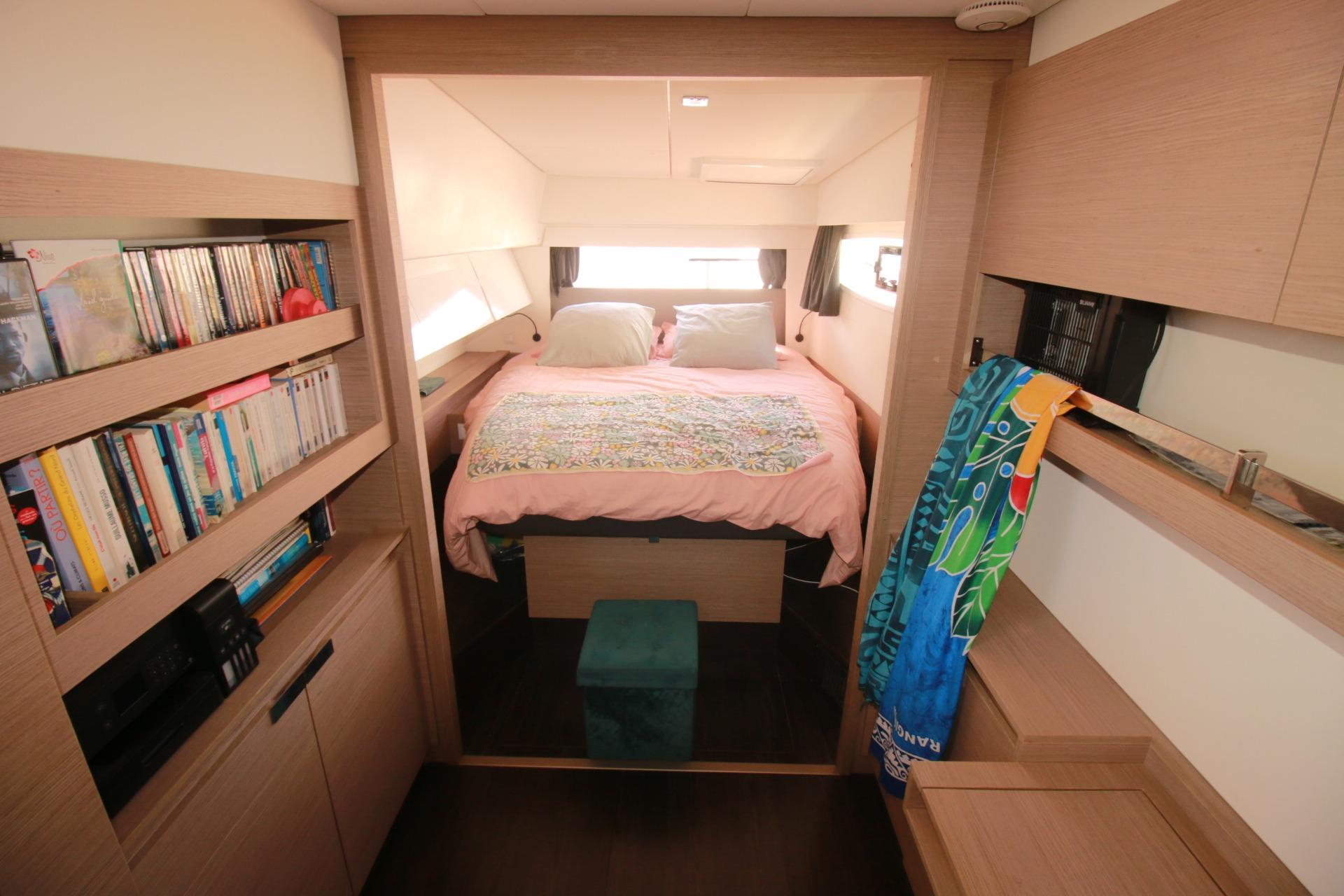 Interior of 2022 Fountaine Pajot Elba 45 Catamaran with cozy bedroom and bookshelves.