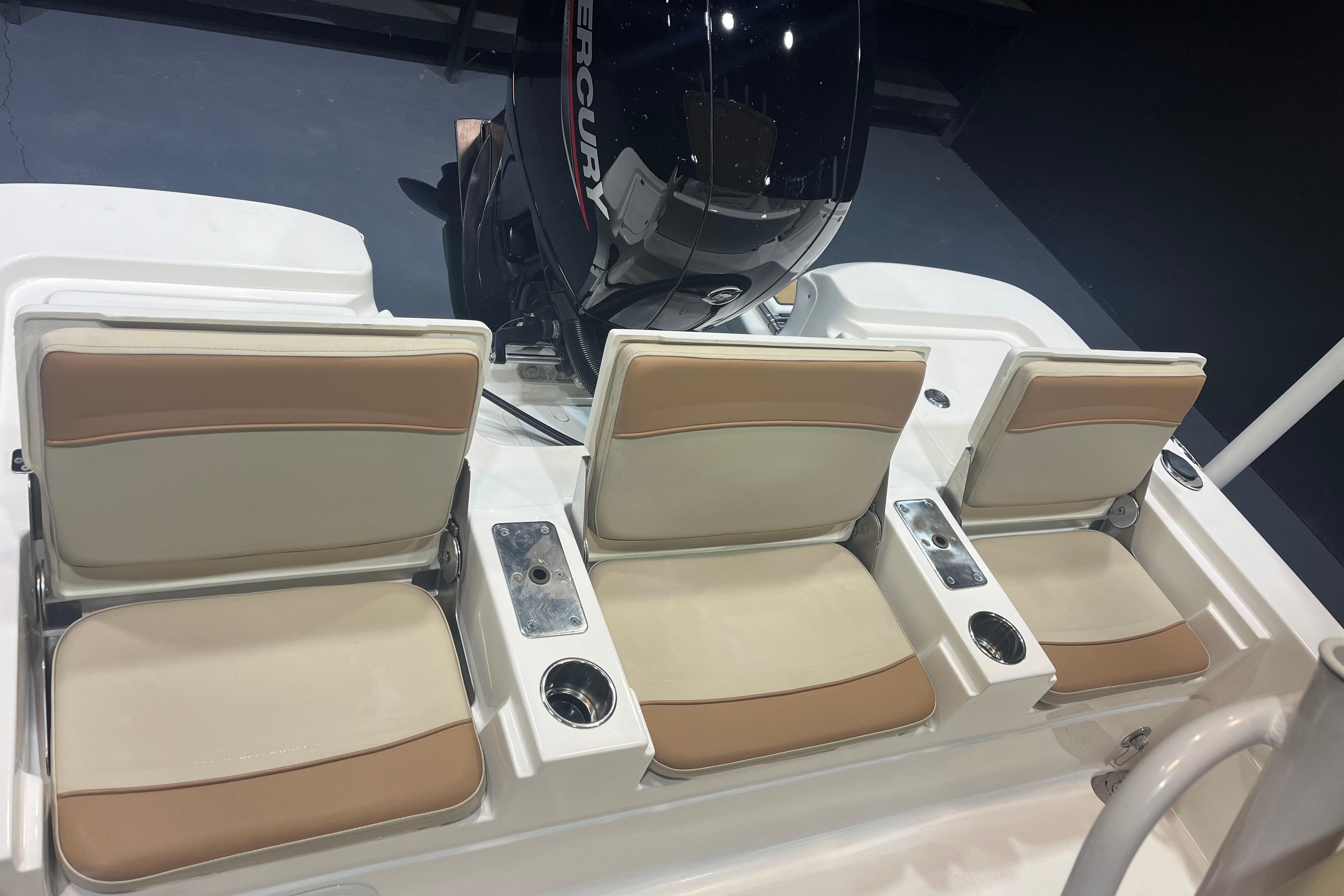 2023 NauticStar 227 XTS boat seats with beige cushions and Mercury engine.