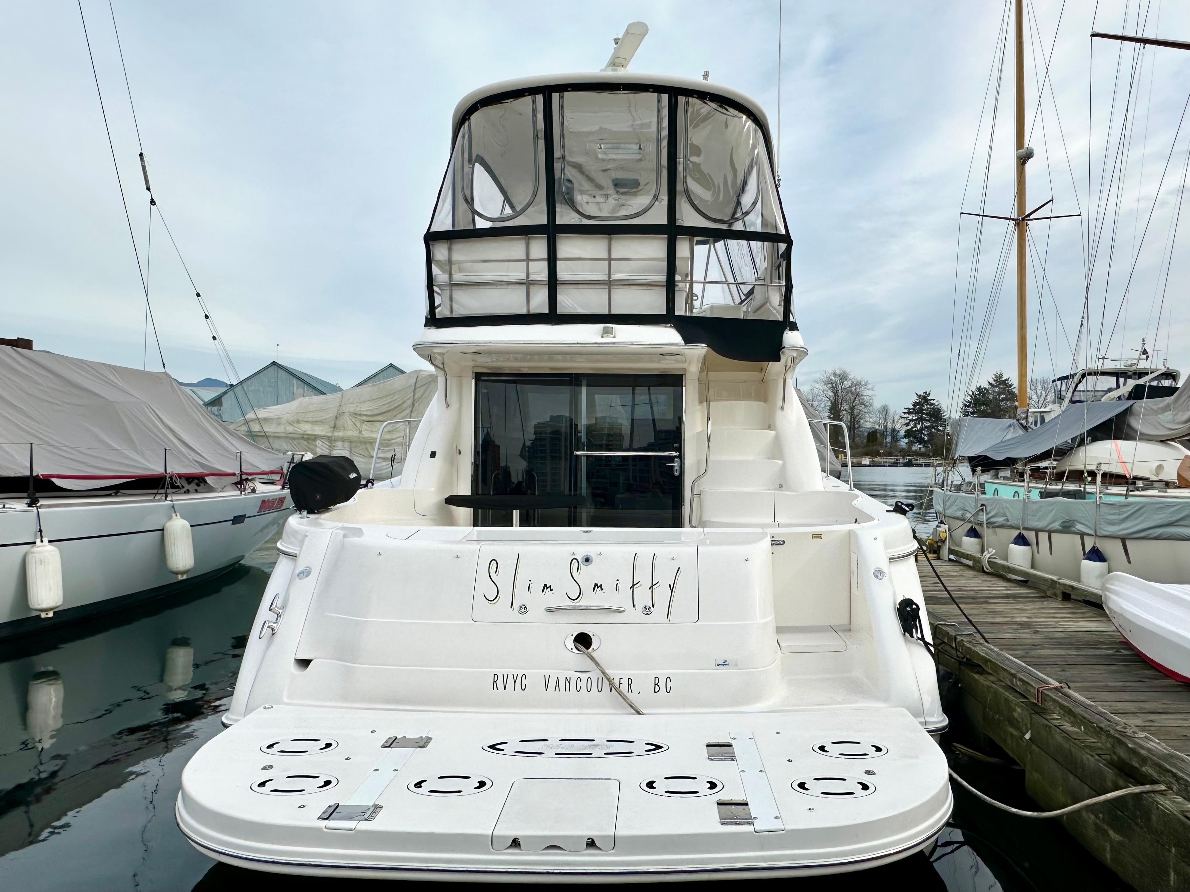 2002 Sea Ray 560 Sedan Bridge yacht docked at marina, rear view.