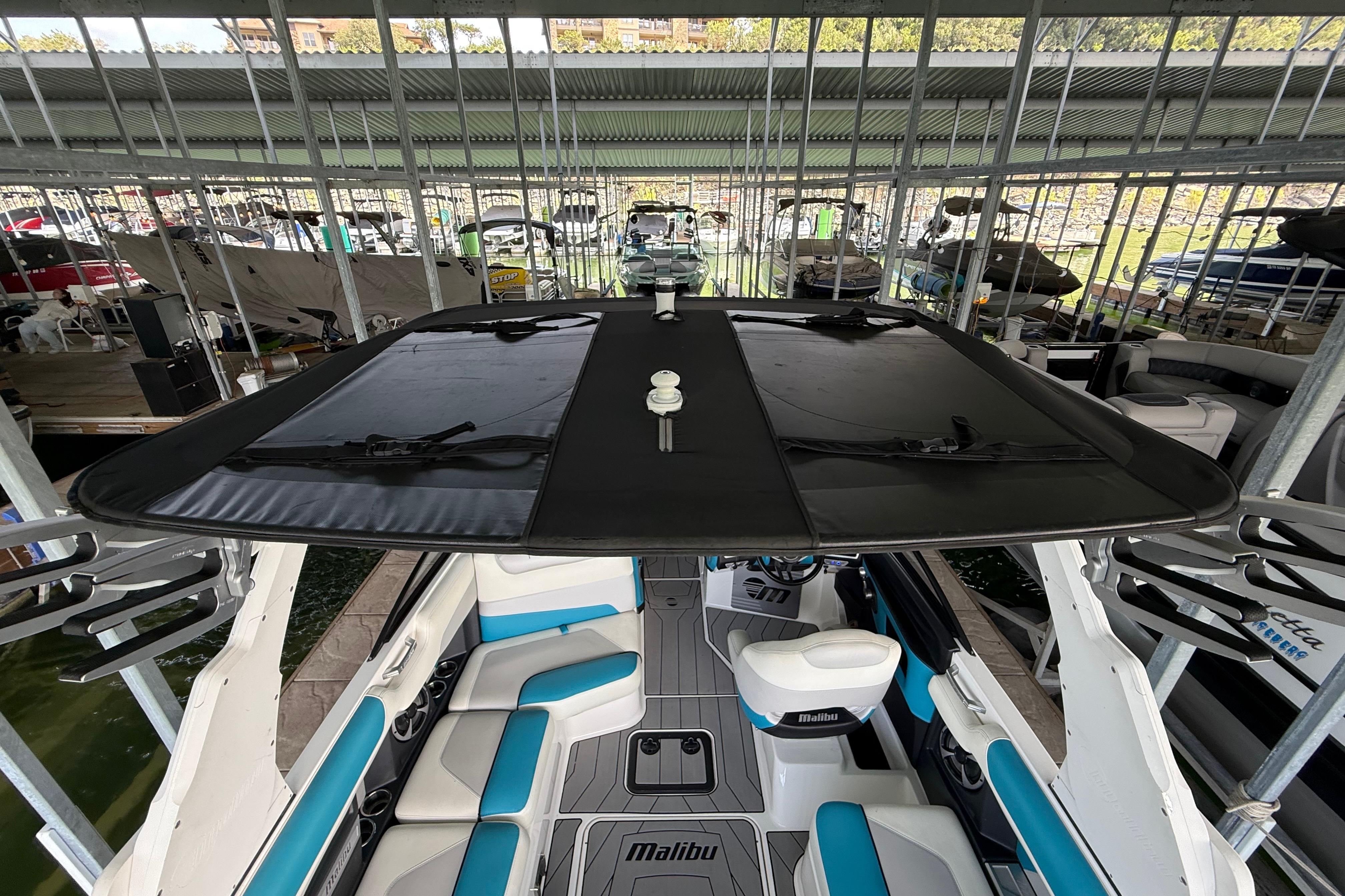 2017 Malibu M235 boat interior with blue and white seating, docked in a marina.