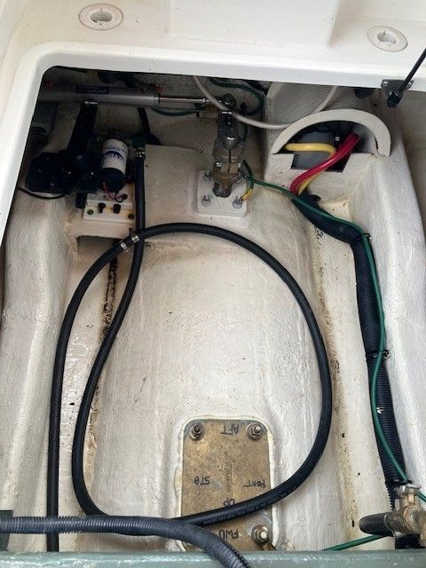 A view inside a boat's engine compartment with cables and hoses.