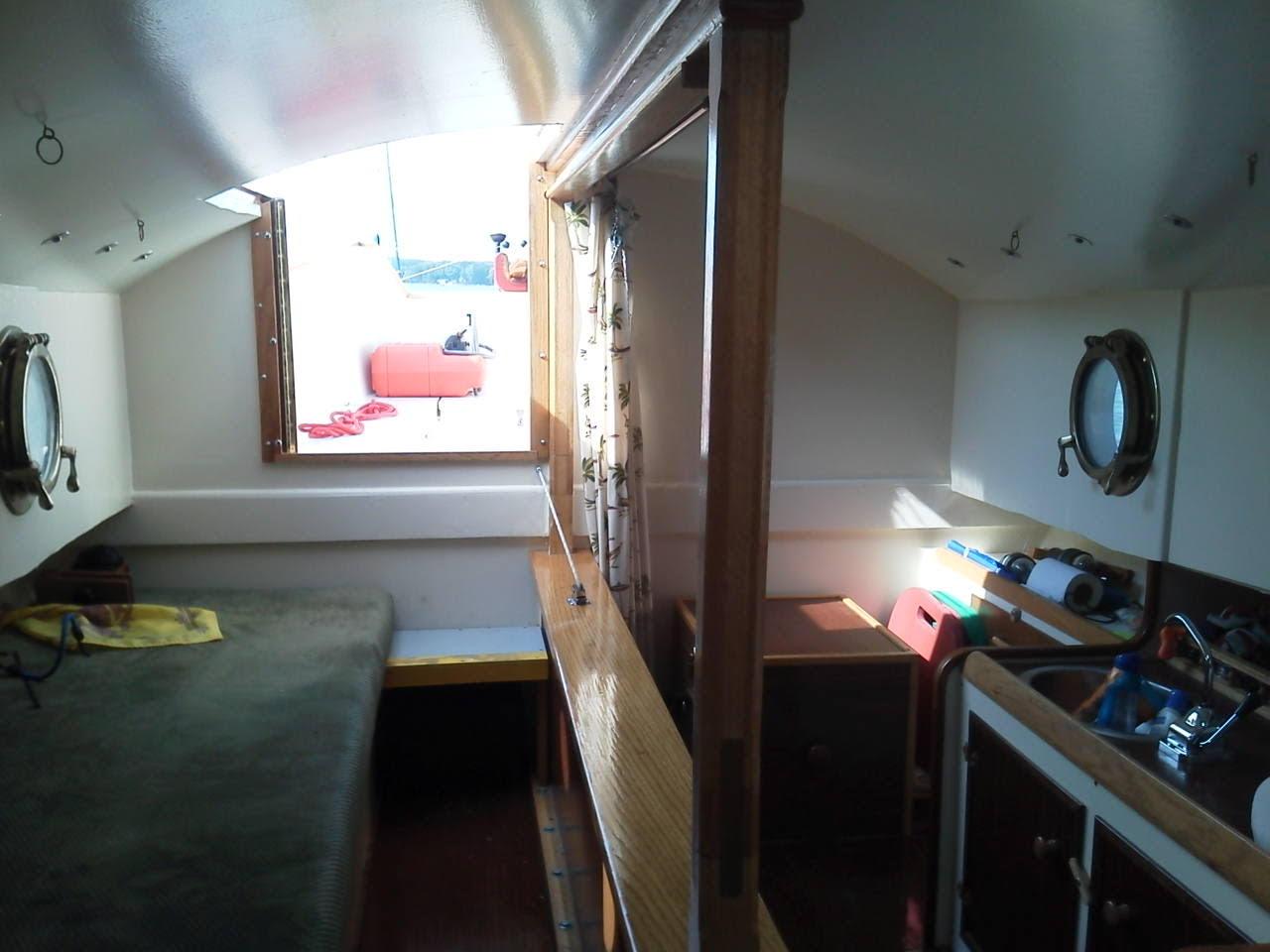 Interior of a 2011 Custom Cat Ketch sailboat with portholes and compact living space.