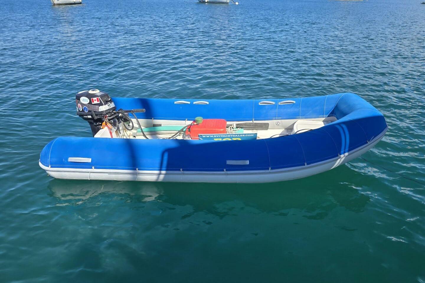 Blue inflatable boat with outboard motor on calm water, Robertson & Caine Leopard 2005 model.