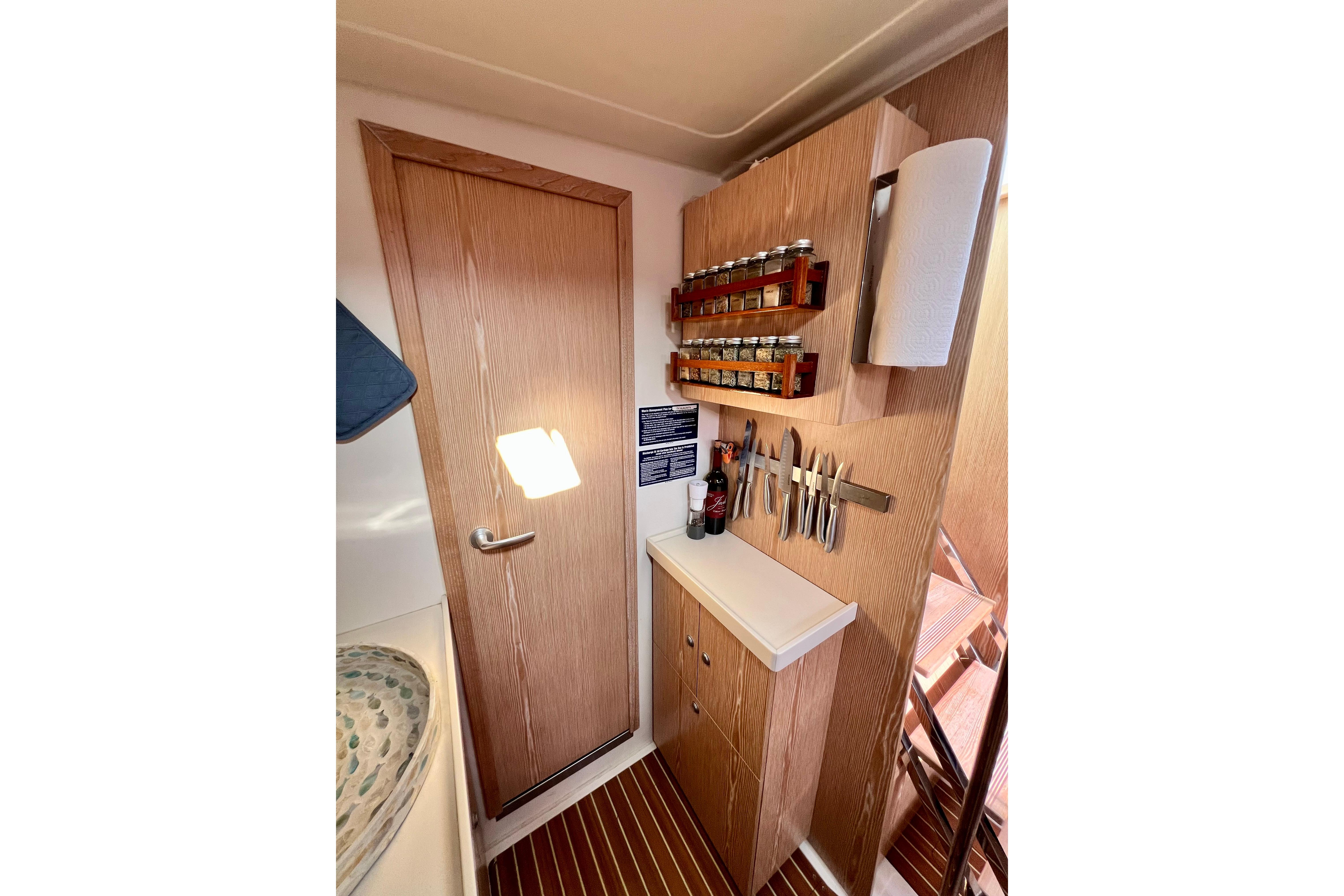 Compact kitchen area in a 2016 Hanse 455 yacht with spice rack and knife holder.