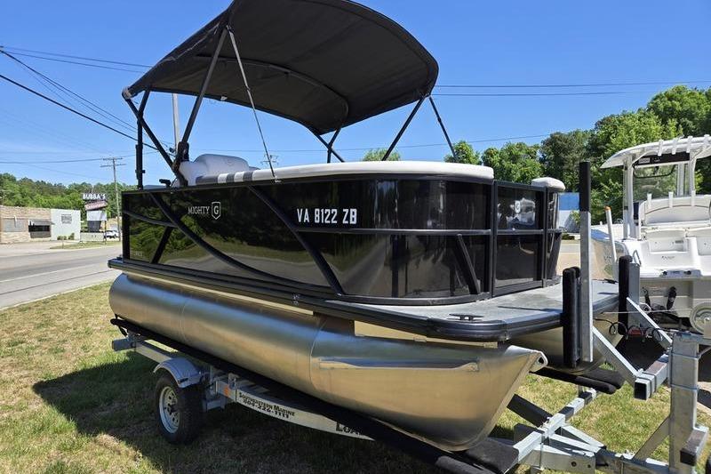 2024 Godfrey Mighty G 1476 C pontoon boat on trailer, parked outdoors.