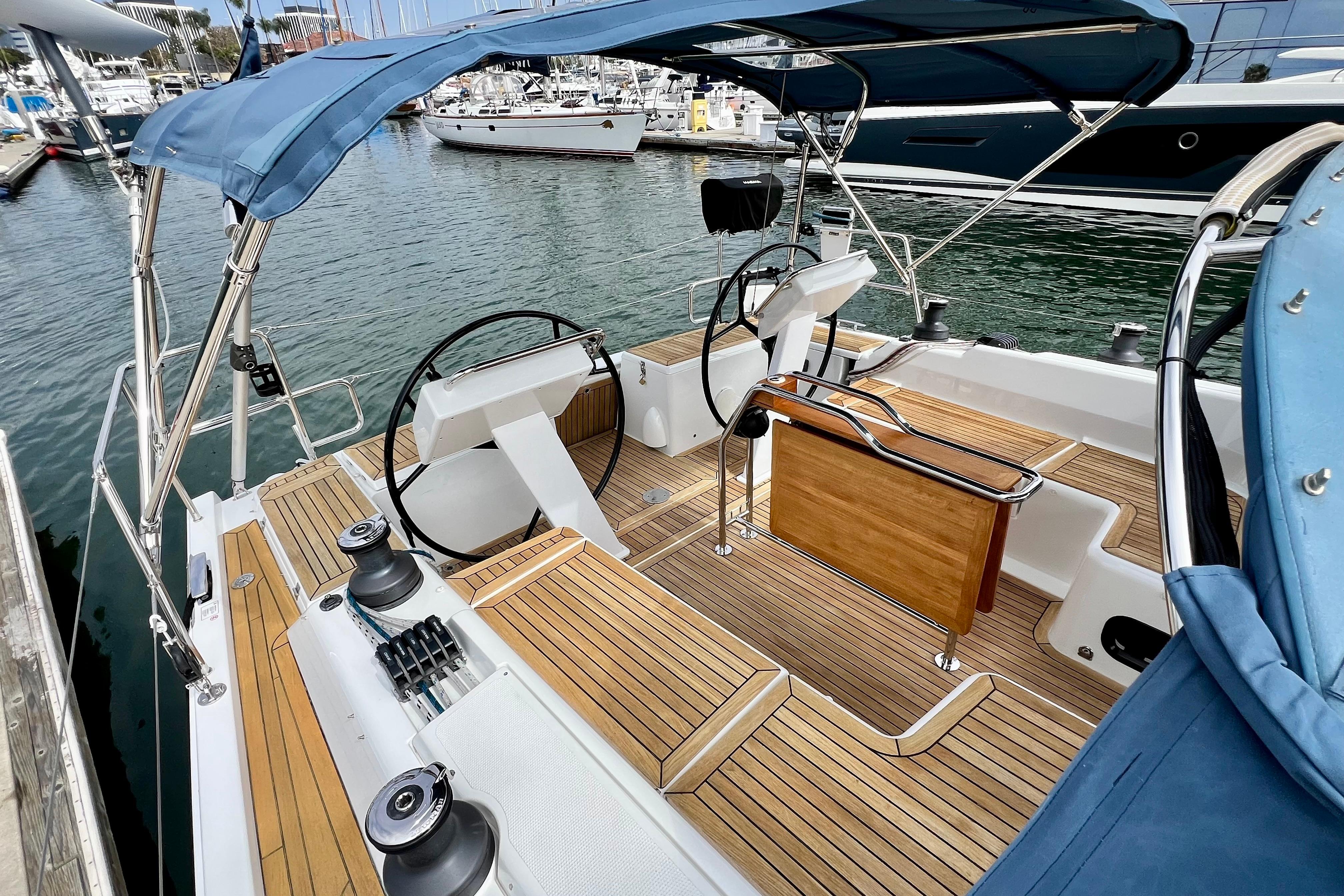 2016 Hanse 455 sailboat cockpit with dual steering wheels and teak decking at marina.