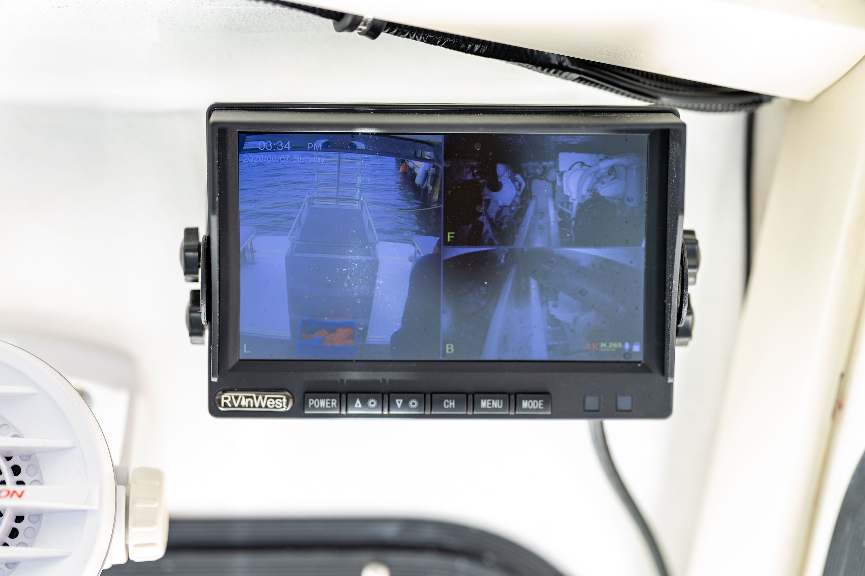 A surveillance monitor displays four camera views on a boat.