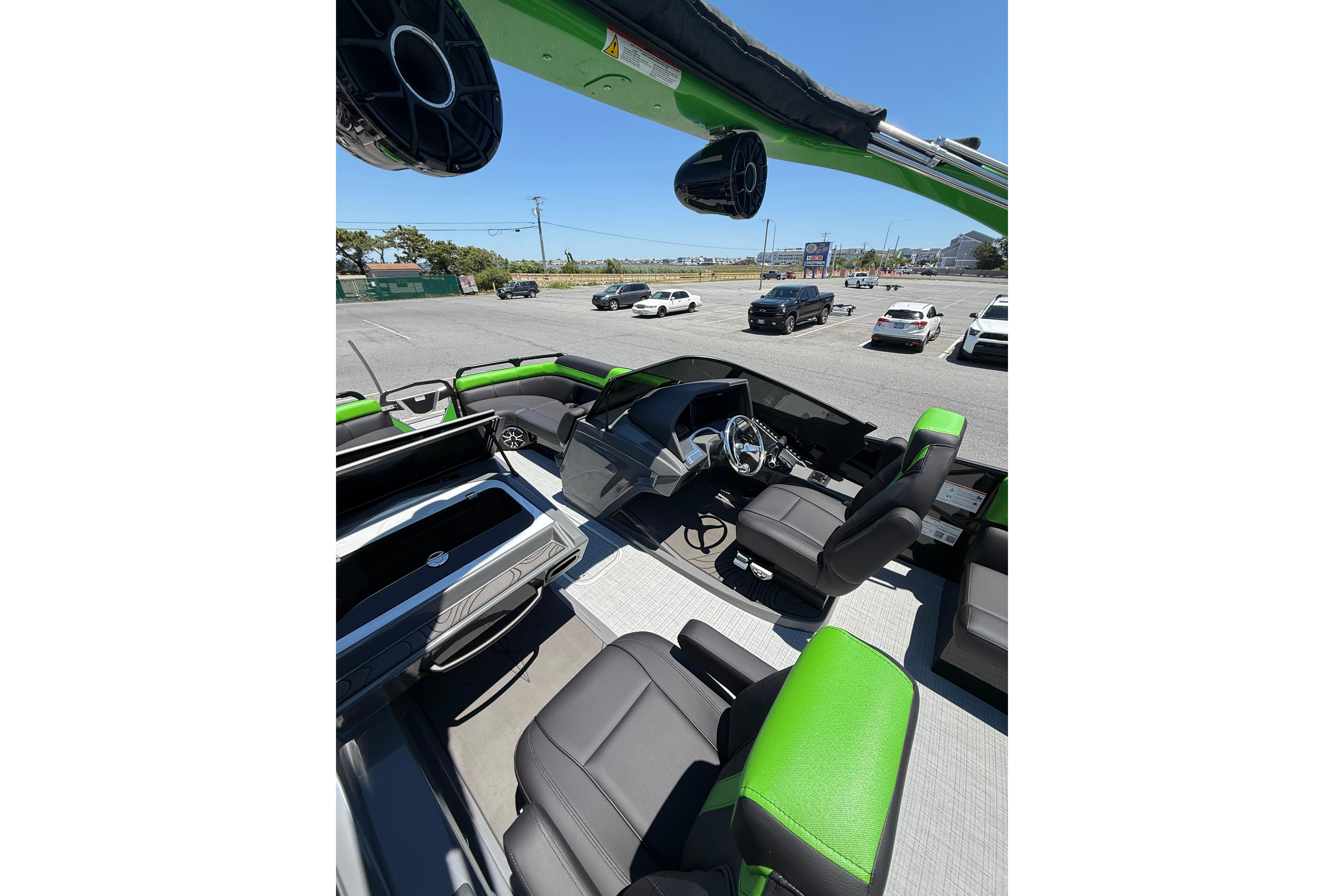2026 Berkshire Sport SLX9 DC boat interior with green and black seating, parked outdoors.