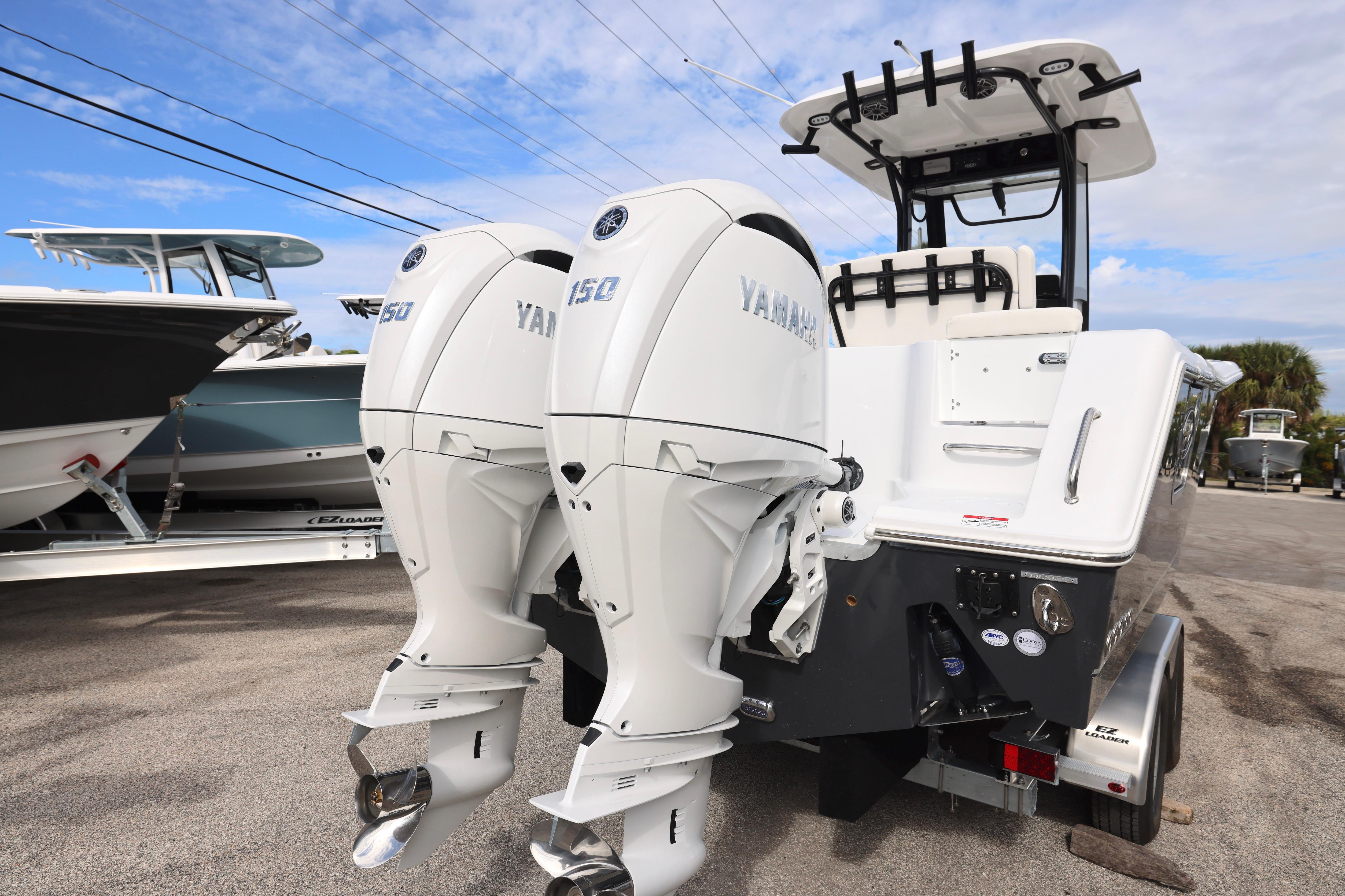 2026 Sea Hunt Gamefish 25 with dual Yamaha 150 engines, parked on a trailer.
